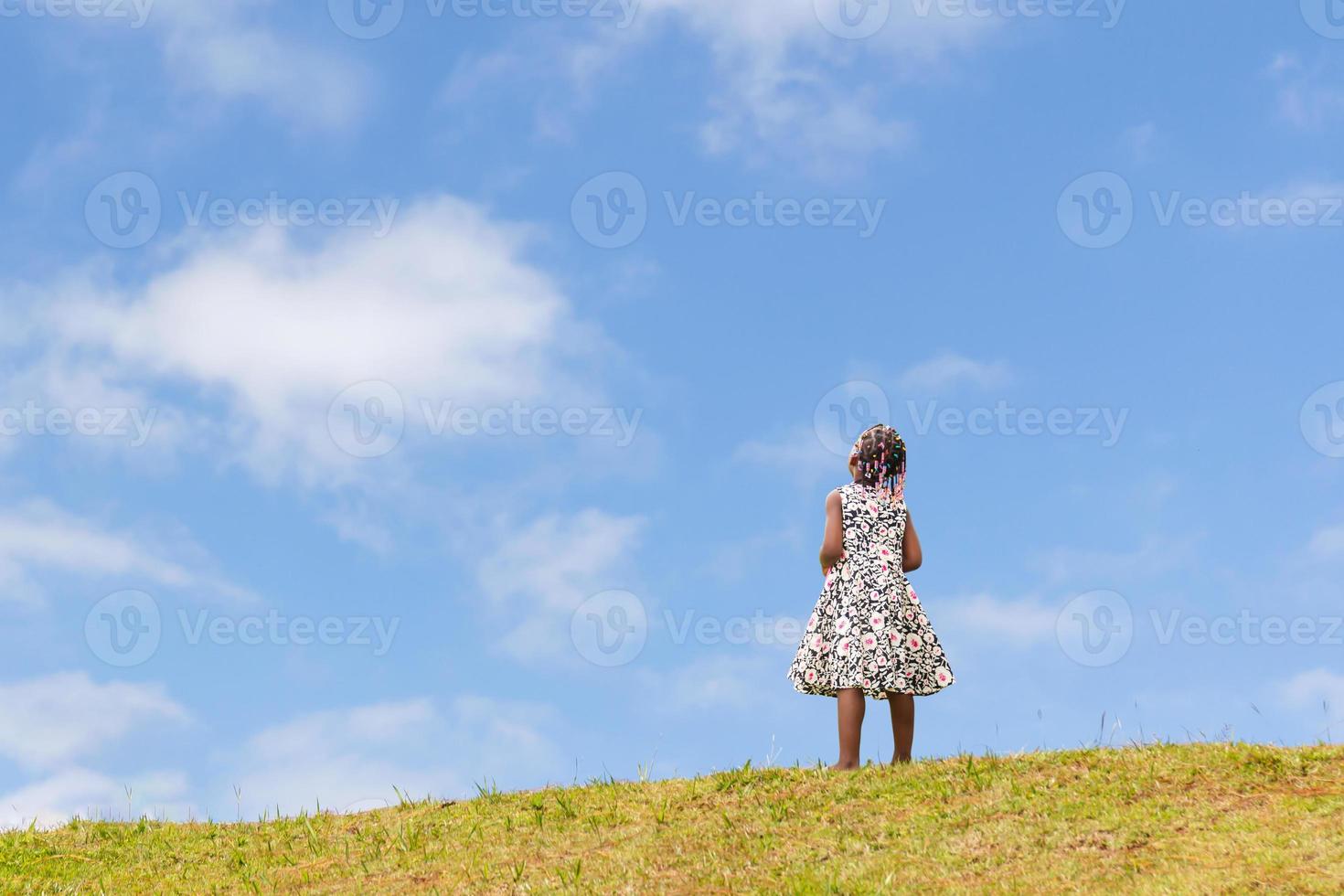 African American kid girl playing outdoors with blue sky background photo