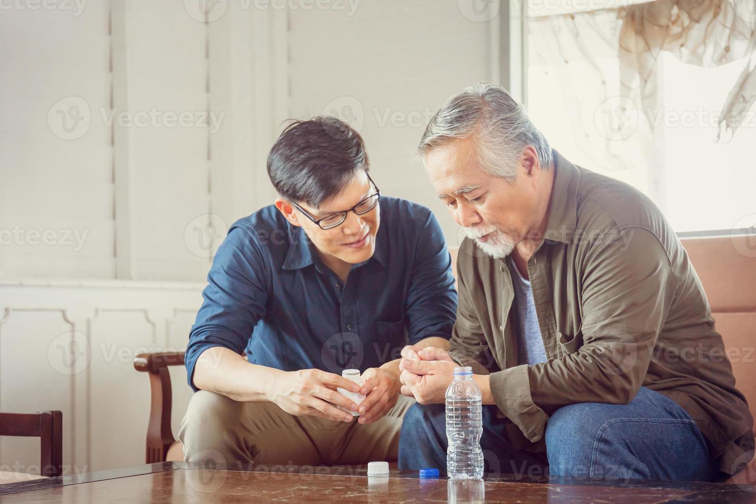 el hijo de mediana edad se ocupa del padre mayor enfermo, los conceptos familiares asiáticos de felicidad foto