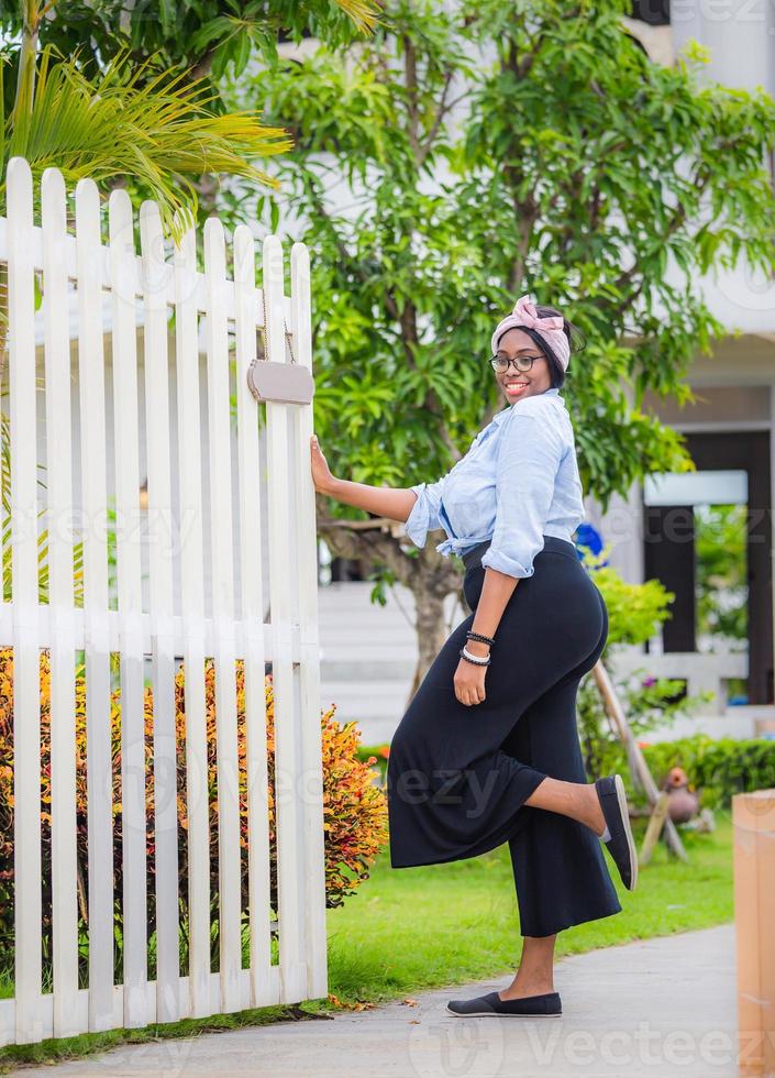 Cheerful african american woman standing and smiling at a new home photo