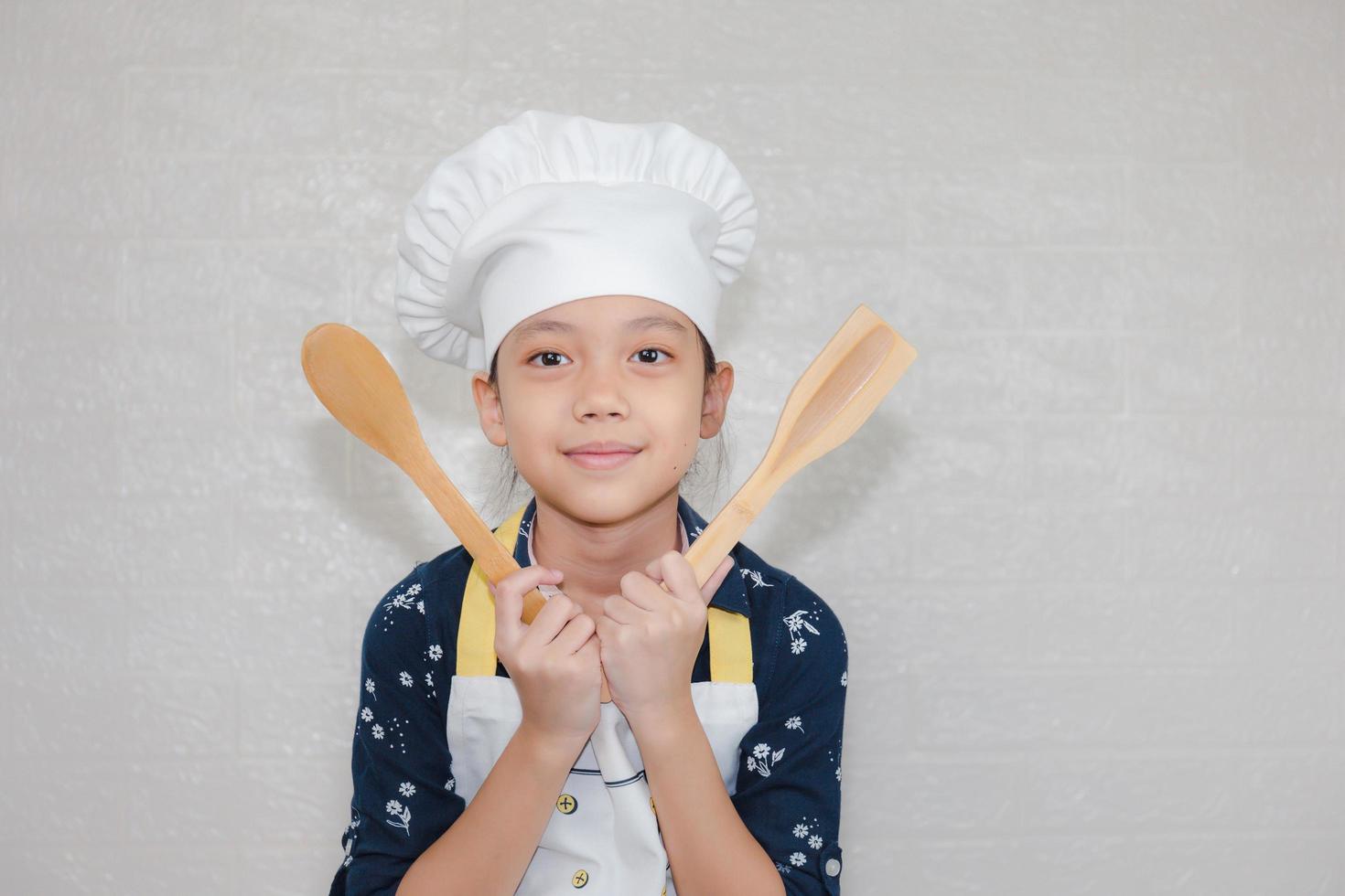 concepto de carreras de ensueño, retrato de niño feliz chef mirando la cámara con fondo borroso foto