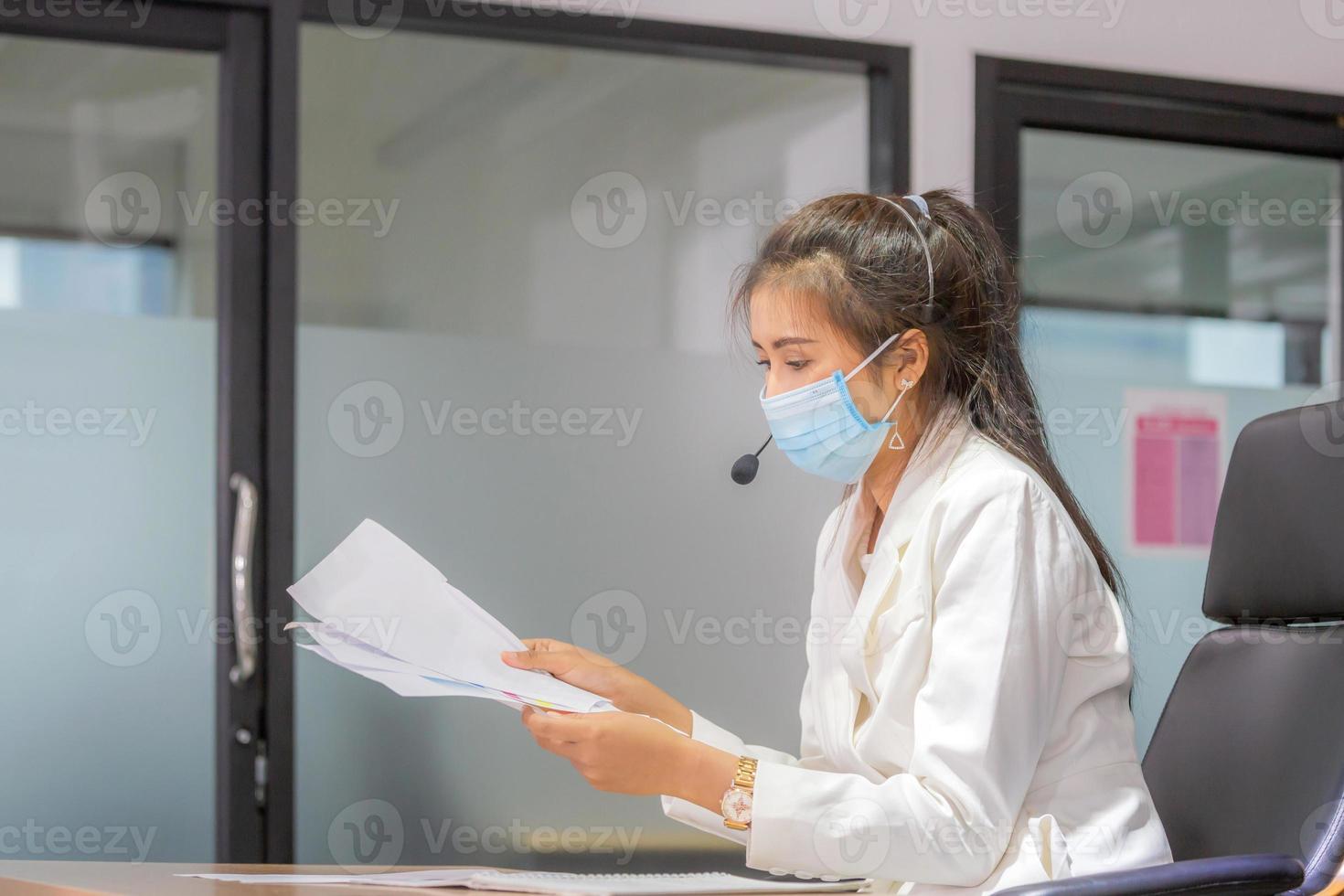 Young woman telephone operator with headset wear protection face mask against coronavirus, Customer service executive team working at office photo