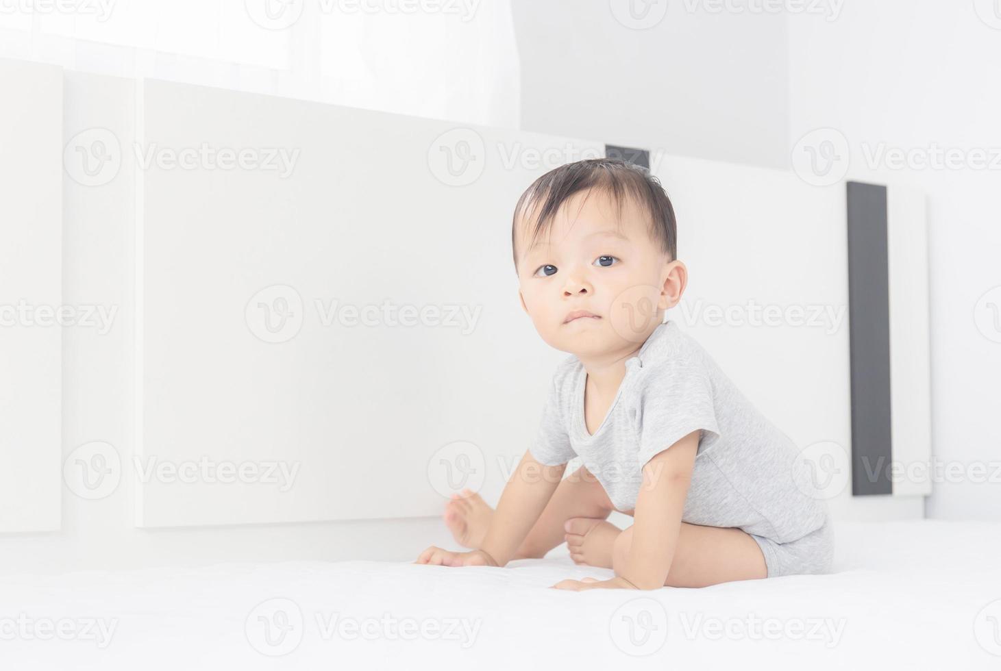 Portrait of a crawling little baby boy on the bed, Kids playing and Happiness concept photo