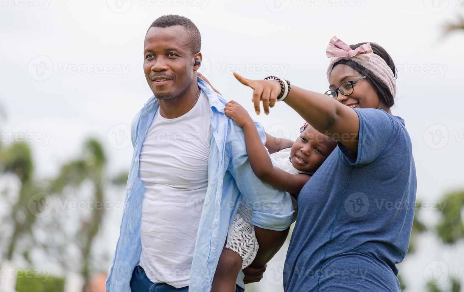 padre feliz madre e hija jugando juntos al aire libre, alegre familia afroamericana disfrutando en el parque, conceptos familiares de felicidad foto