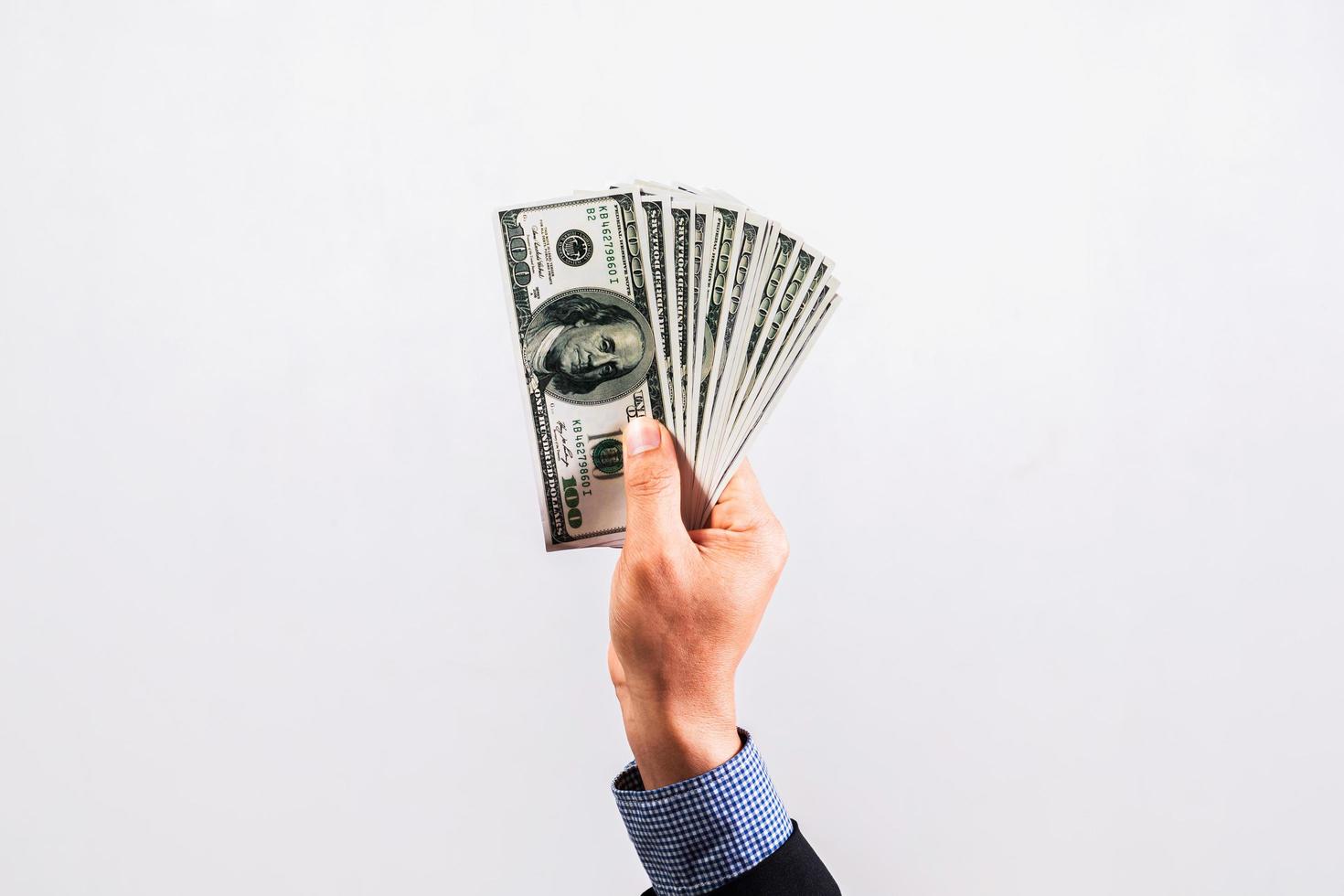 Businessman in suit holding several 100 dollar bills. Finance concept. photo