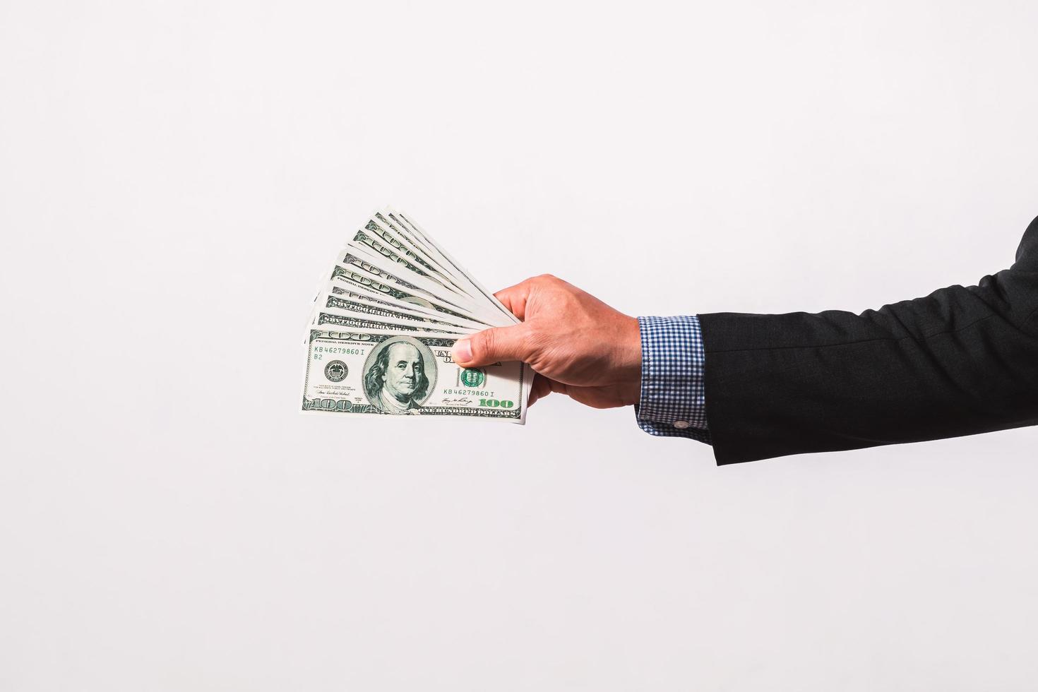 Businessman in suit holding several 100 dollar bills. Finance concept. photo