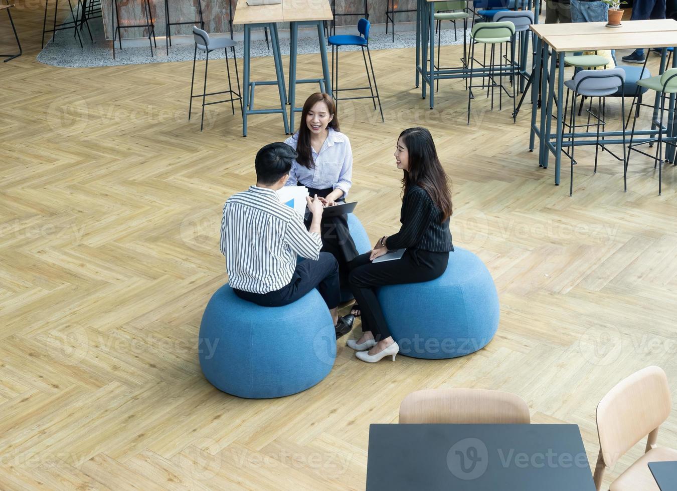 grupo de jóvenes equipos de negocios discuten algo mientras se sientan juntos en la mesa del espacio de trabajo conjunto, planifican la estrategia y la lluvia de ideas, los colegas piensan en el concepto foto