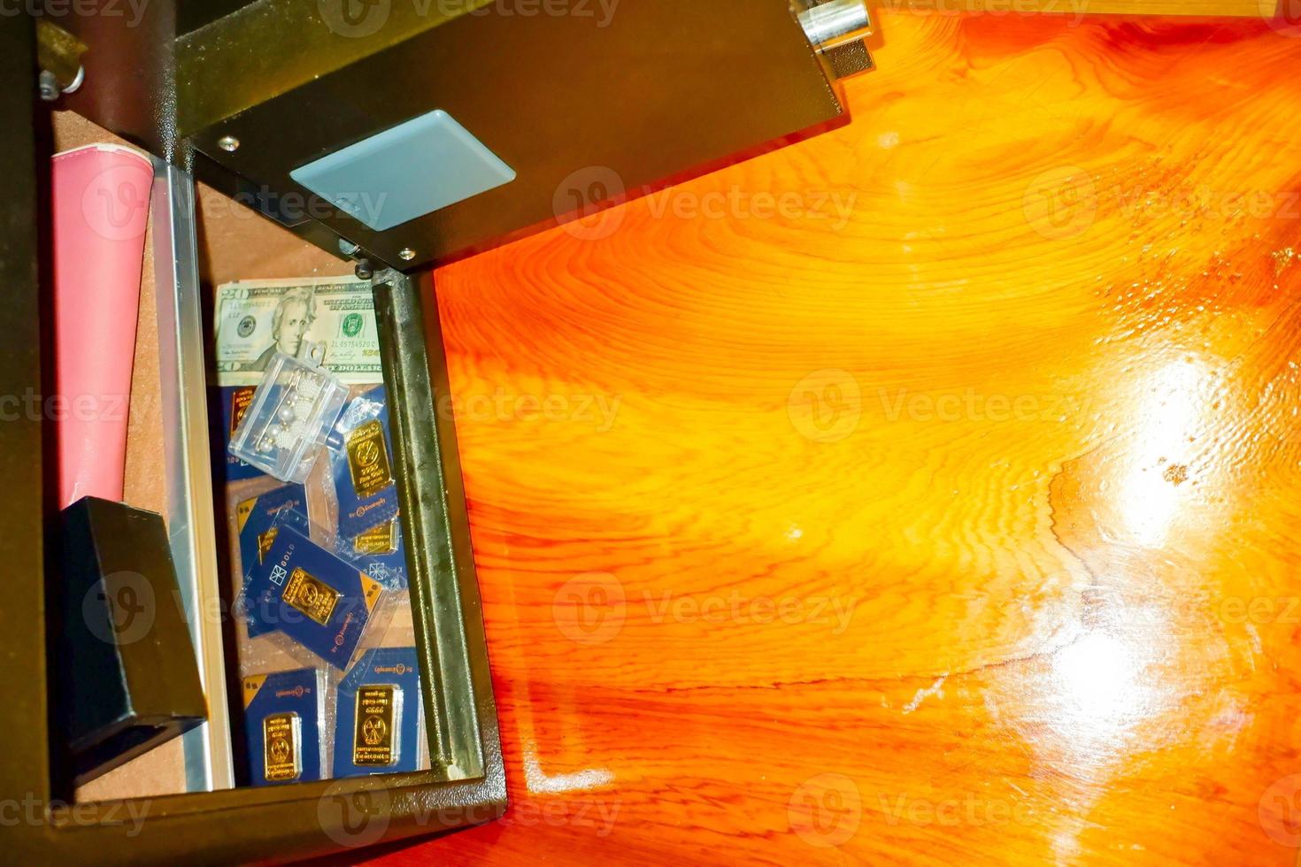 Open treasure chest filled with fine gold and Bank note dollar... on wooden table background. photo