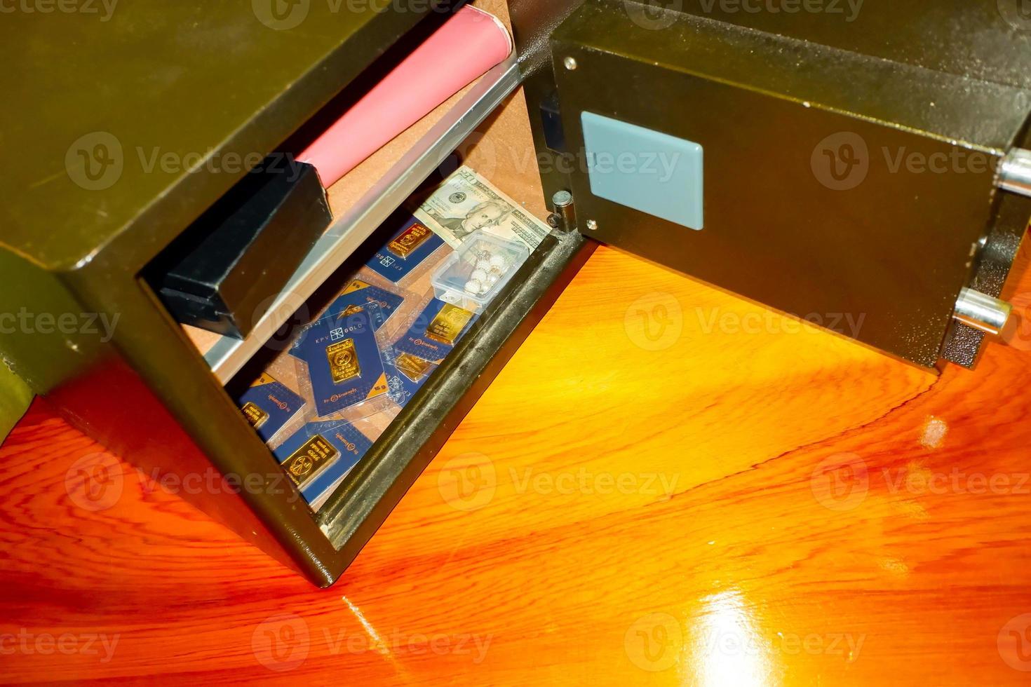 Open treasure chest filled with fine gold and Bank note dollar... on wooden table background. photo