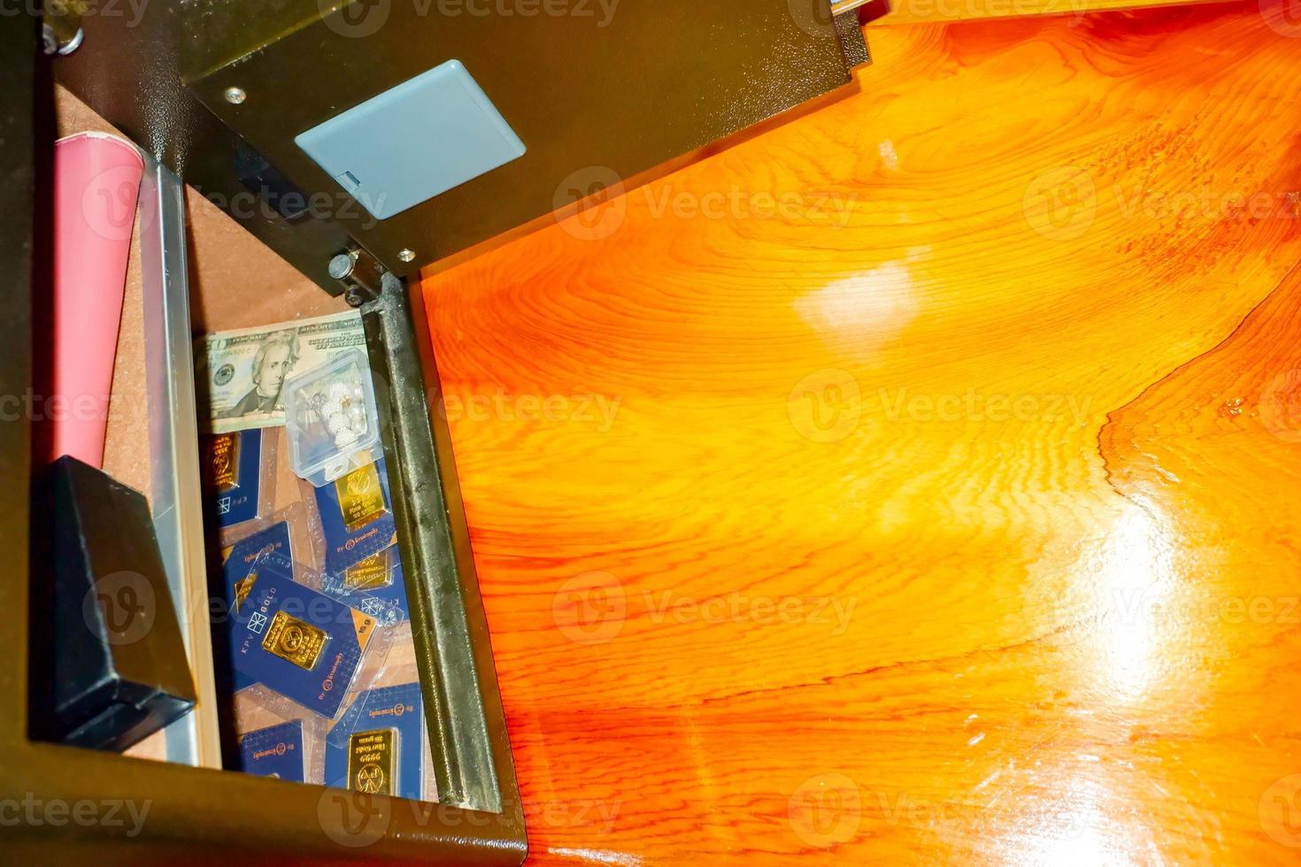 Open treasure chest filled with fine gold and Bank note dollar... on wooden table background. photo