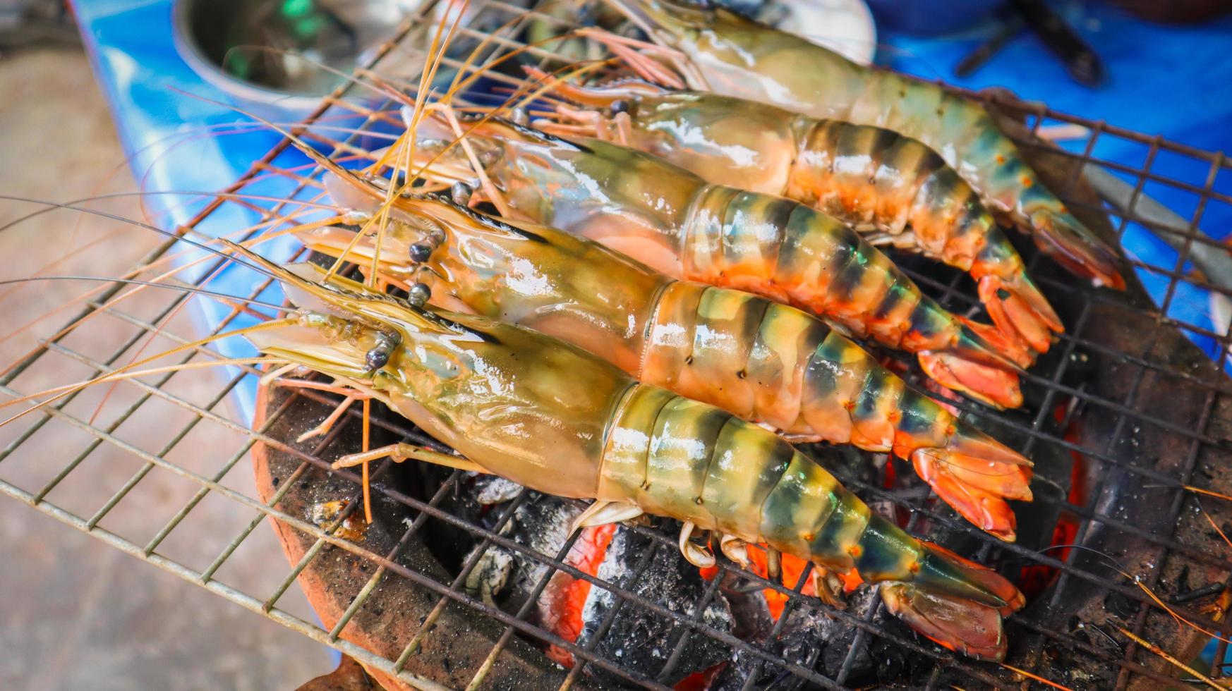 Fresh large river prawn grilled on flaming grill using charcoal stove. photo