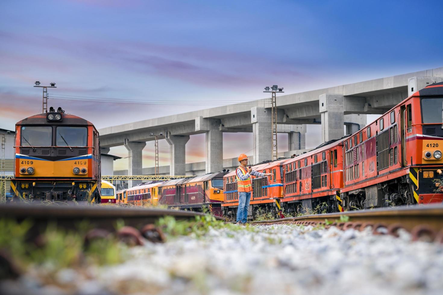 Engineer railway under  checking construction process train testing and checking railway work on railroad station with radio communication .Engineer wearing safety uniform and safety helmet in work. photo