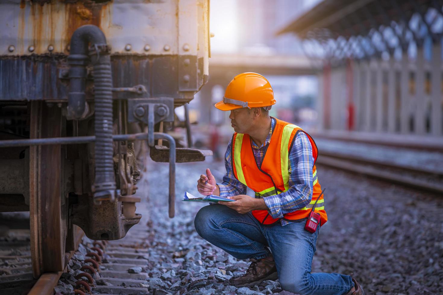 Engineer railway under  checking construction process train testing and checking railway work on railroad station with radio communication .Engineer wearing safety uniform and safety helmet in work. photo