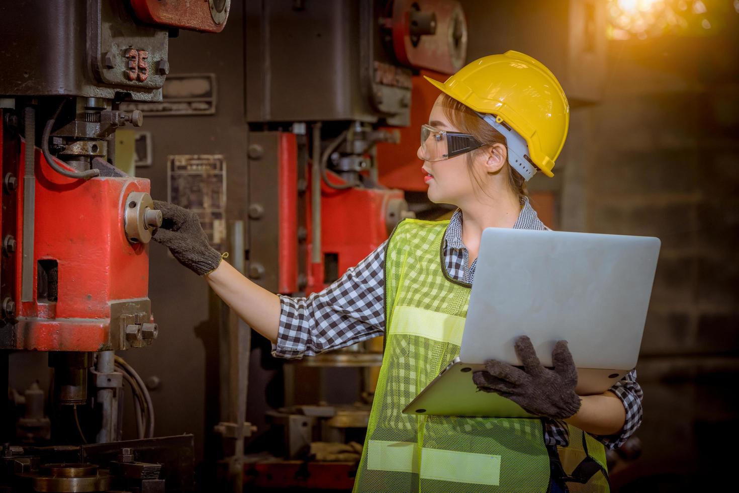 ingeniería industrial y trabajo en equipo con control uniforme de seguridad que opera la máquina rectificadora de torno que trabaja en la fábrica de la industria. foto