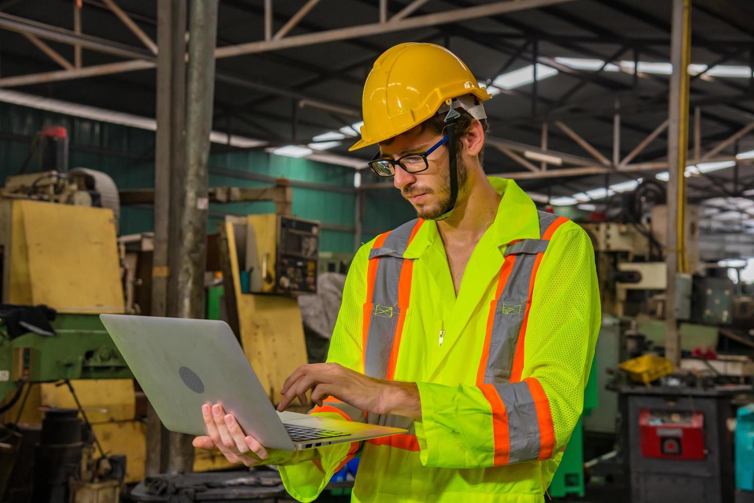 ingeniería industrial y trabajo en equipo con control uniforme de seguridad que opera la máquina rectificadora de torno que trabaja en la fábrica de la industria. foto