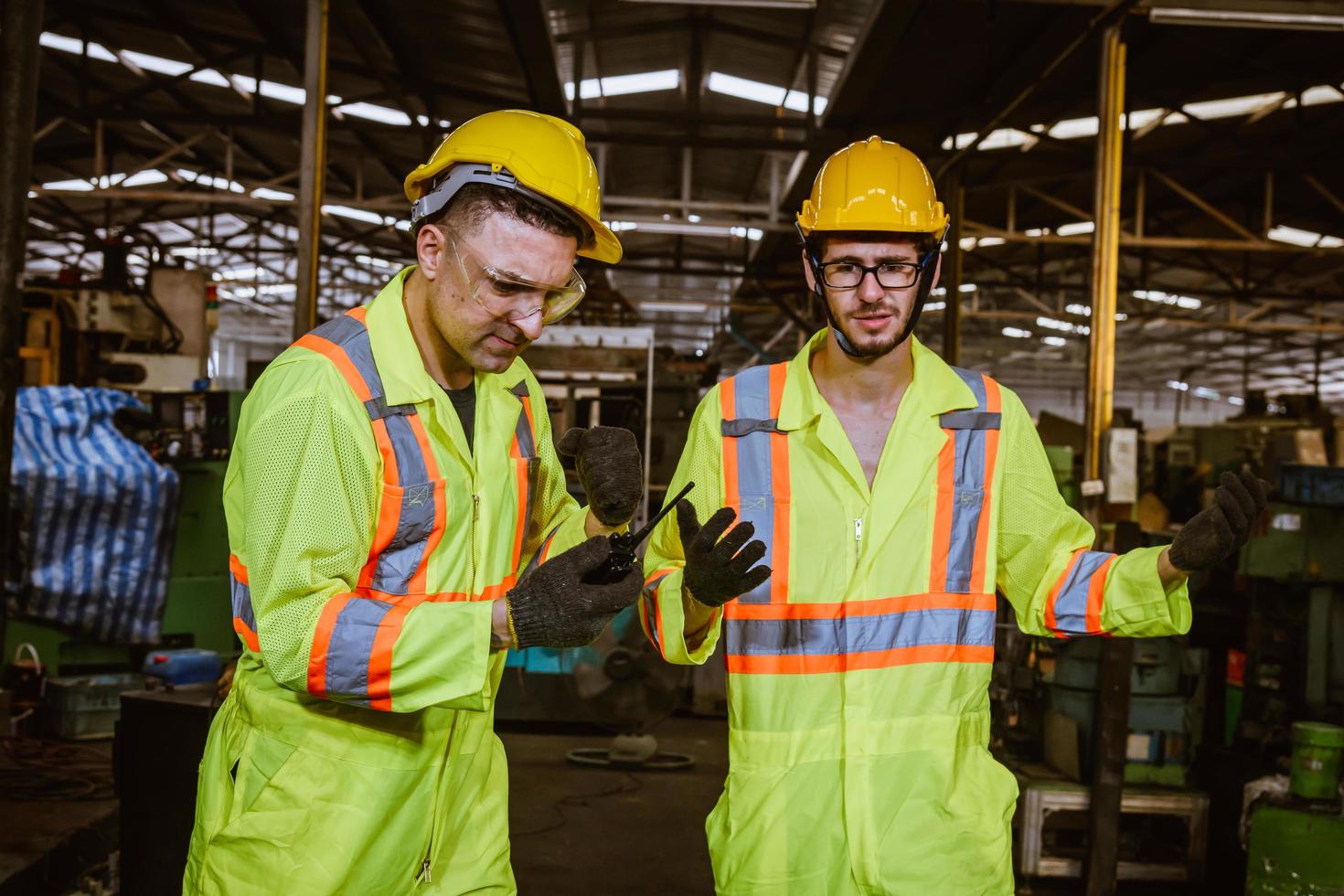 ingeniería industrial y trabajo en equipo con control uniforme de seguridad que opera la máquina rectificadora de torno que trabaja en la fábrica de la industria. foto