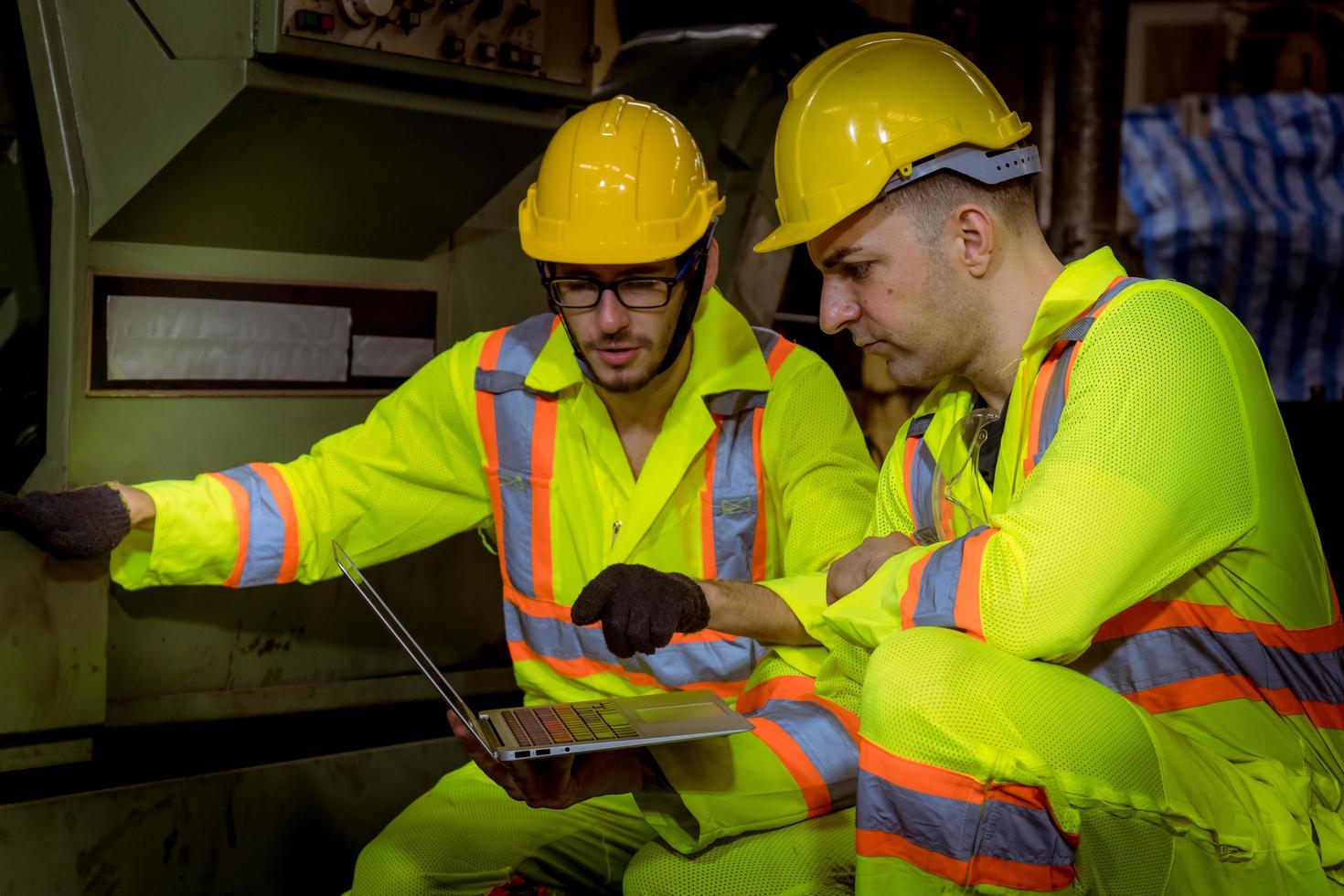 ingeniería industrial y trabajo en equipo con control uniforme de seguridad que opera la máquina rectificadora de torno que trabaja en la fábrica de la industria. foto