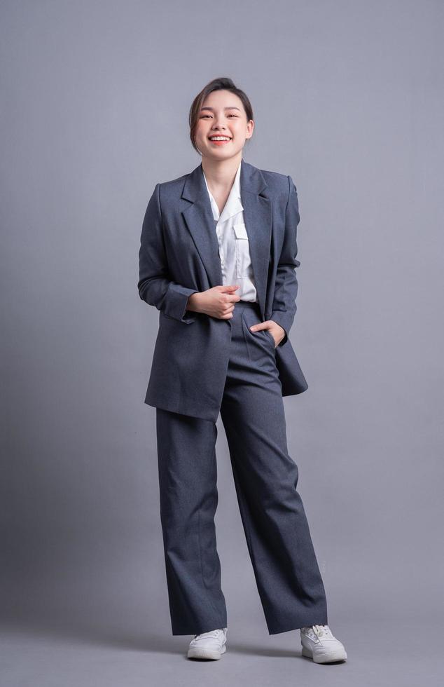 Young Asian business woman standing on gray background photo