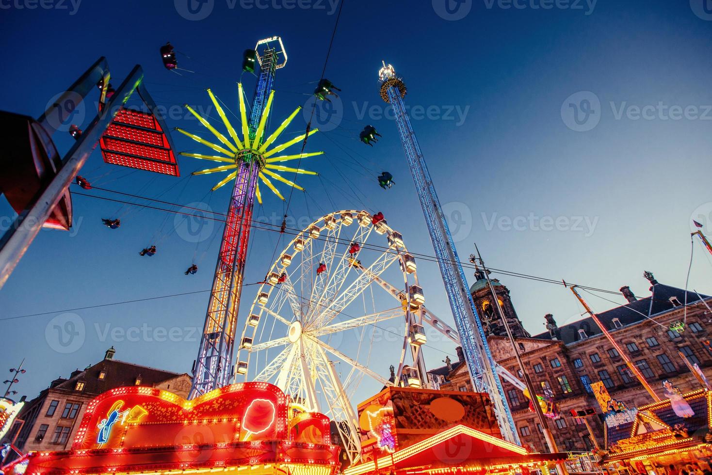 carrusel del parque de atracciones. hermosa iluminación nocturna. un cuento de hadas para niños foto