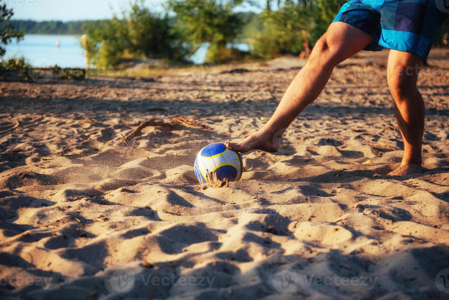 young guy playing volleyball on the beach photo