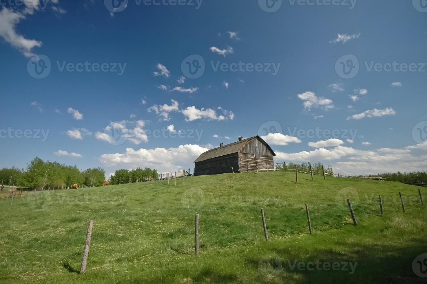 Russian barn on a green hill and blue sky photo