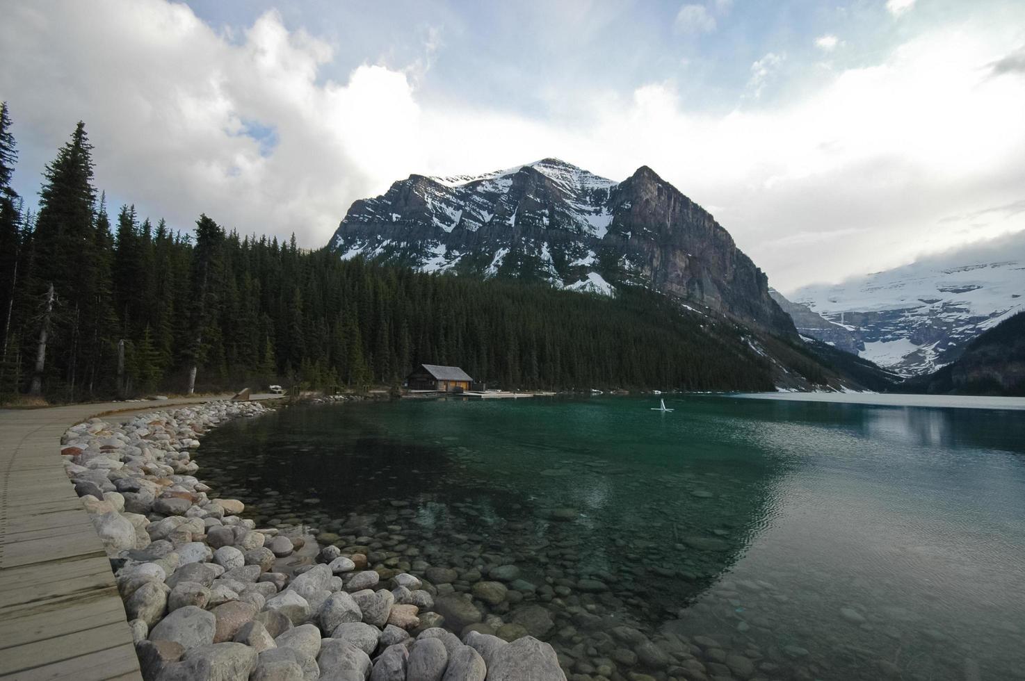 walk way near pristine lake and snow mountain photo