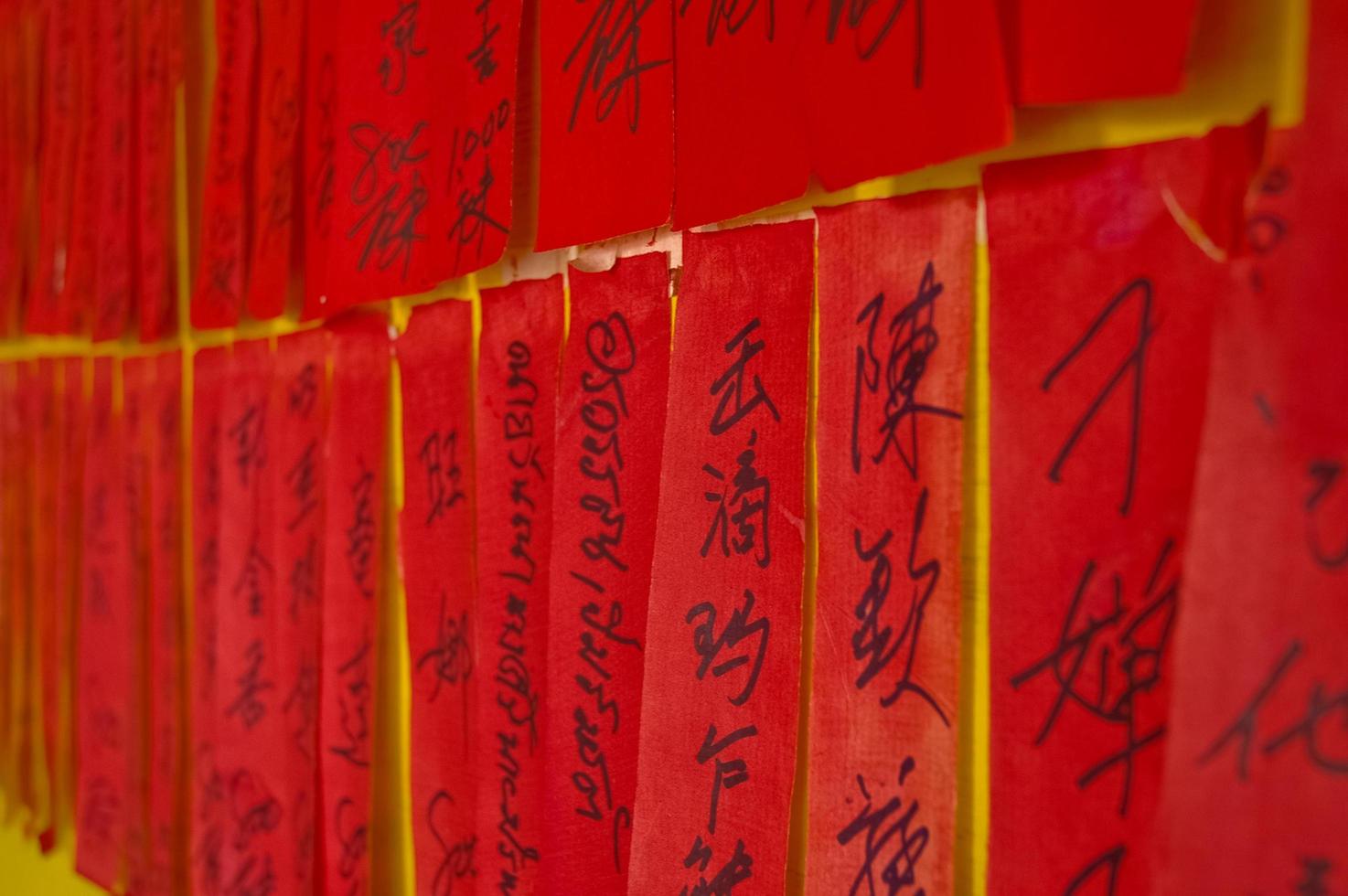 caracteres caligráficos chinos escritos a mano en etiquetas rojas foto