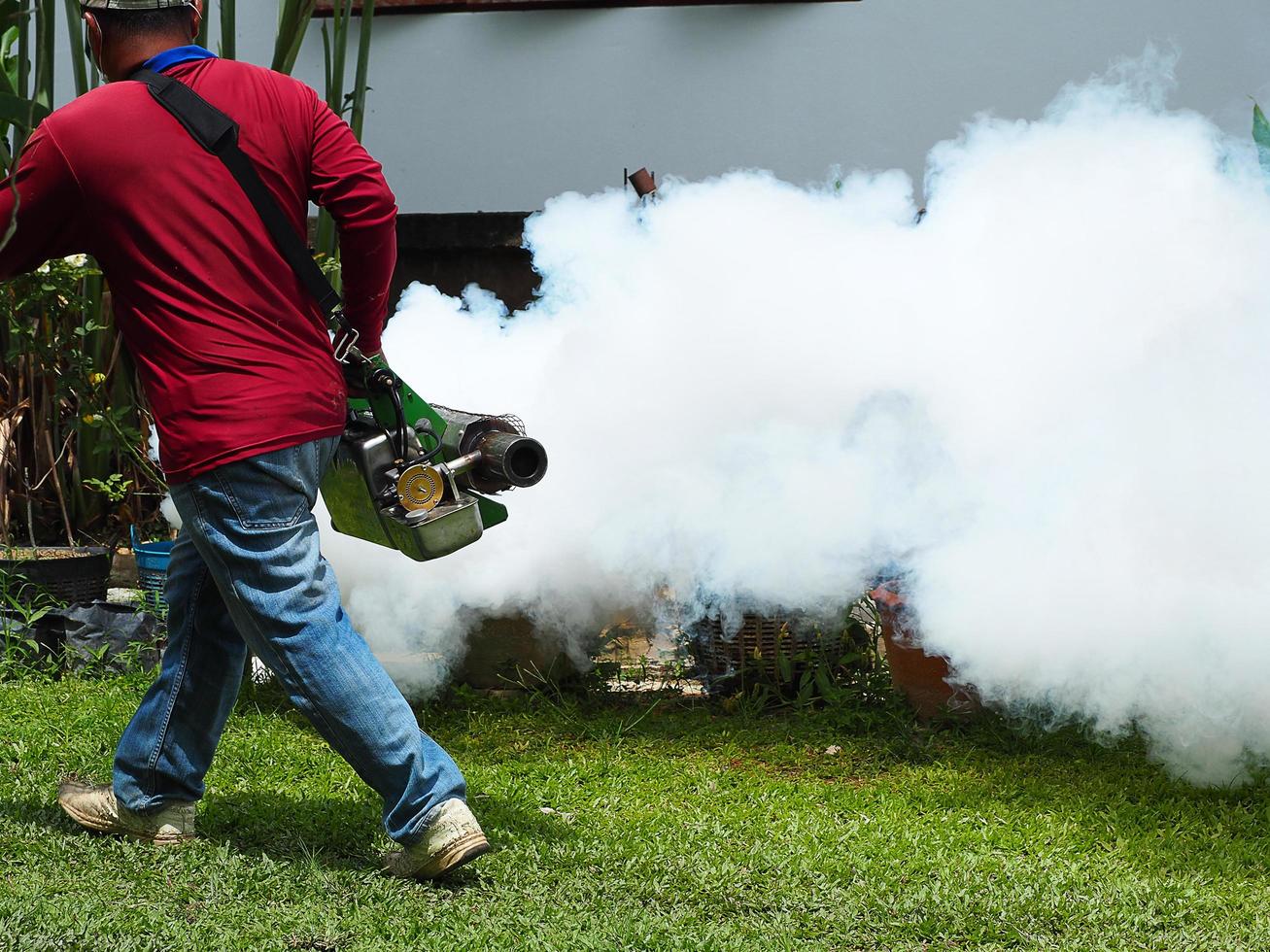 Young man worker are working fogging to eliminate mosquitoes photo