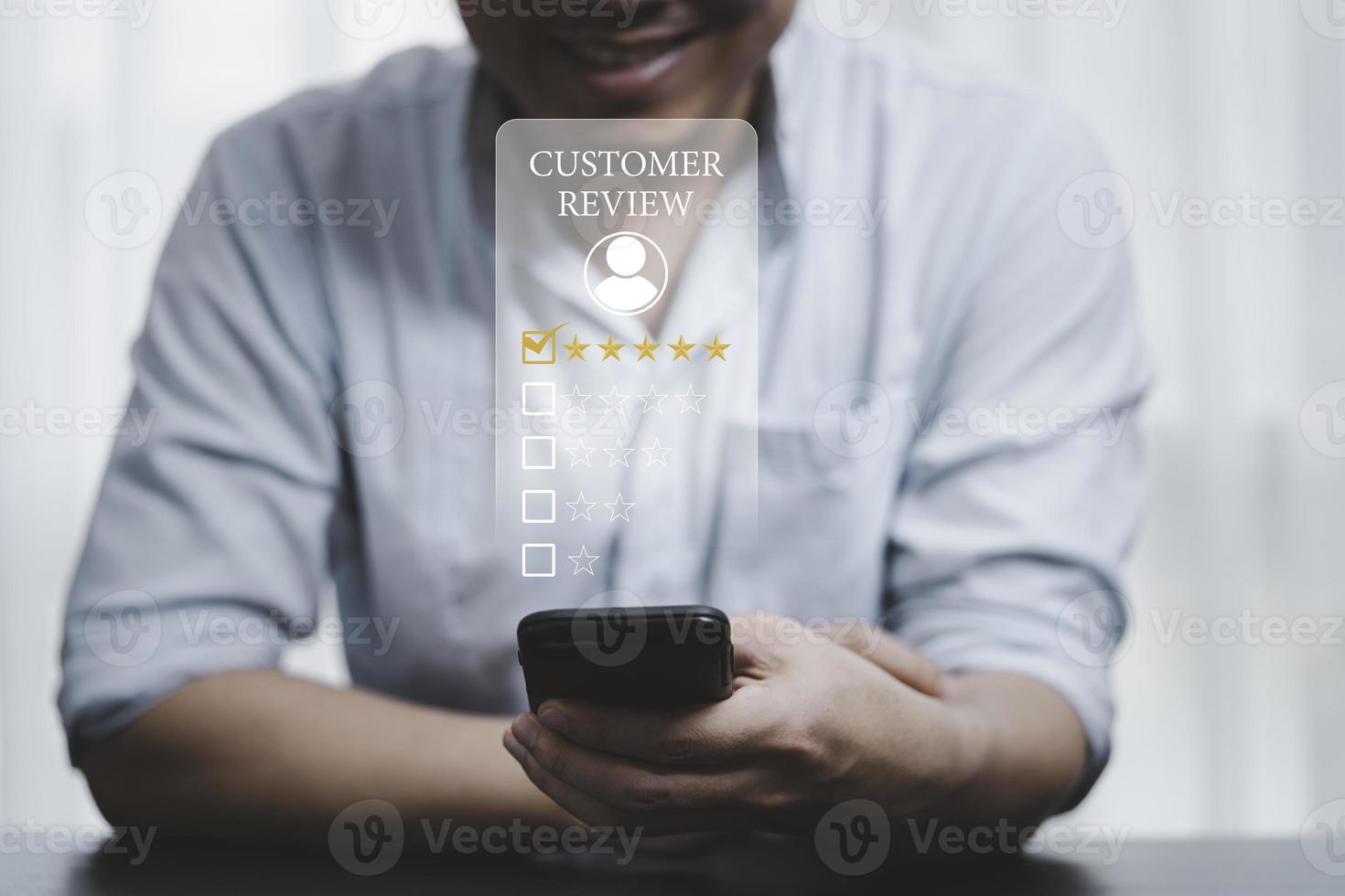 hombre de negocios que usa un teléfono inteligente para seleccionar el icono de la cara sonriente para la evaluación del cliente y la satisfacción del cliente después de usar el concepto de producto y servicio. foto