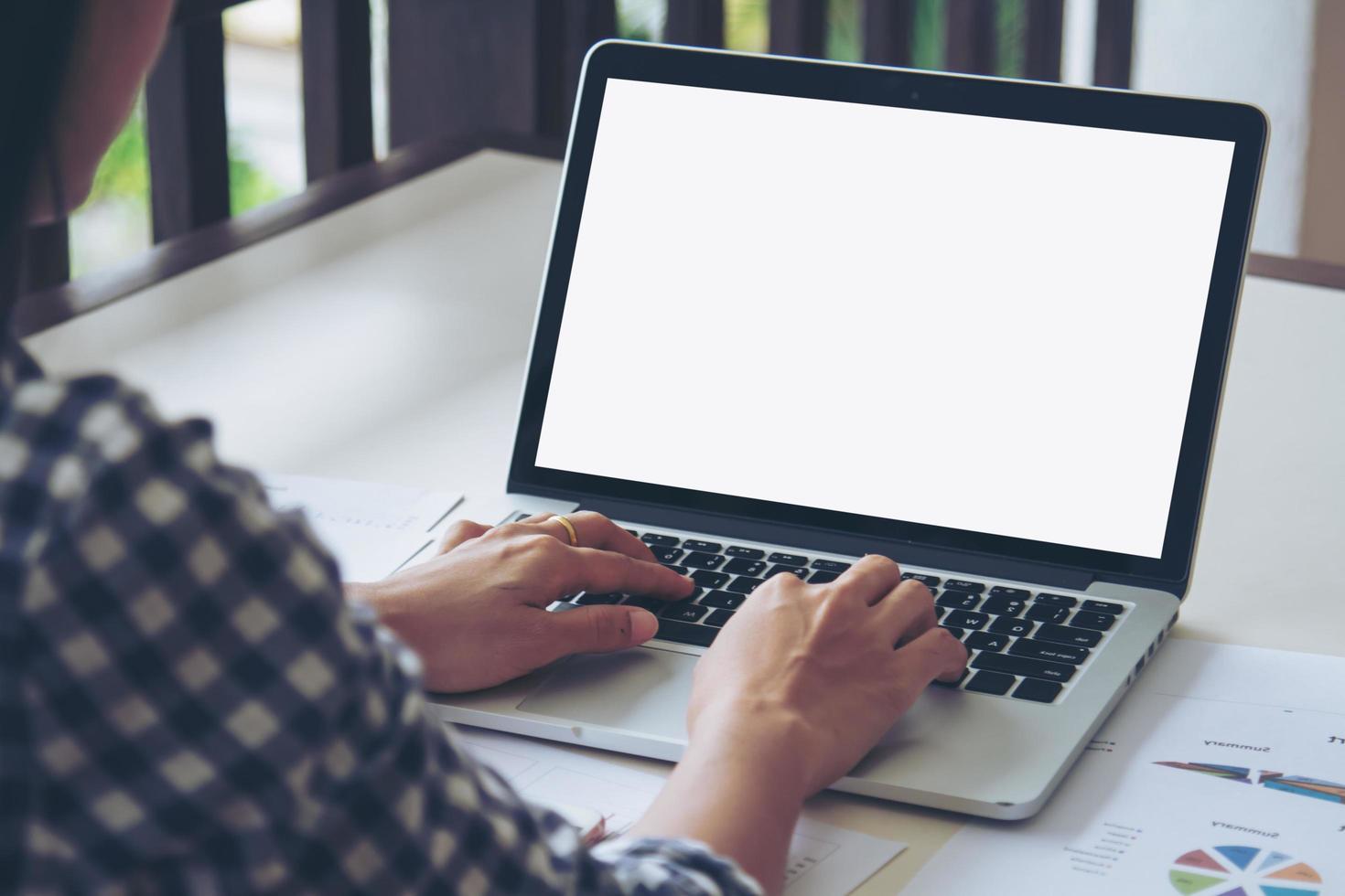 mujer de negocios escribiendo en el teclado portátil trabajando en un informe comercial. la pantalla en blanco con espacio de copia para su texto o contenido publicitario. enfoque selectivo. foto