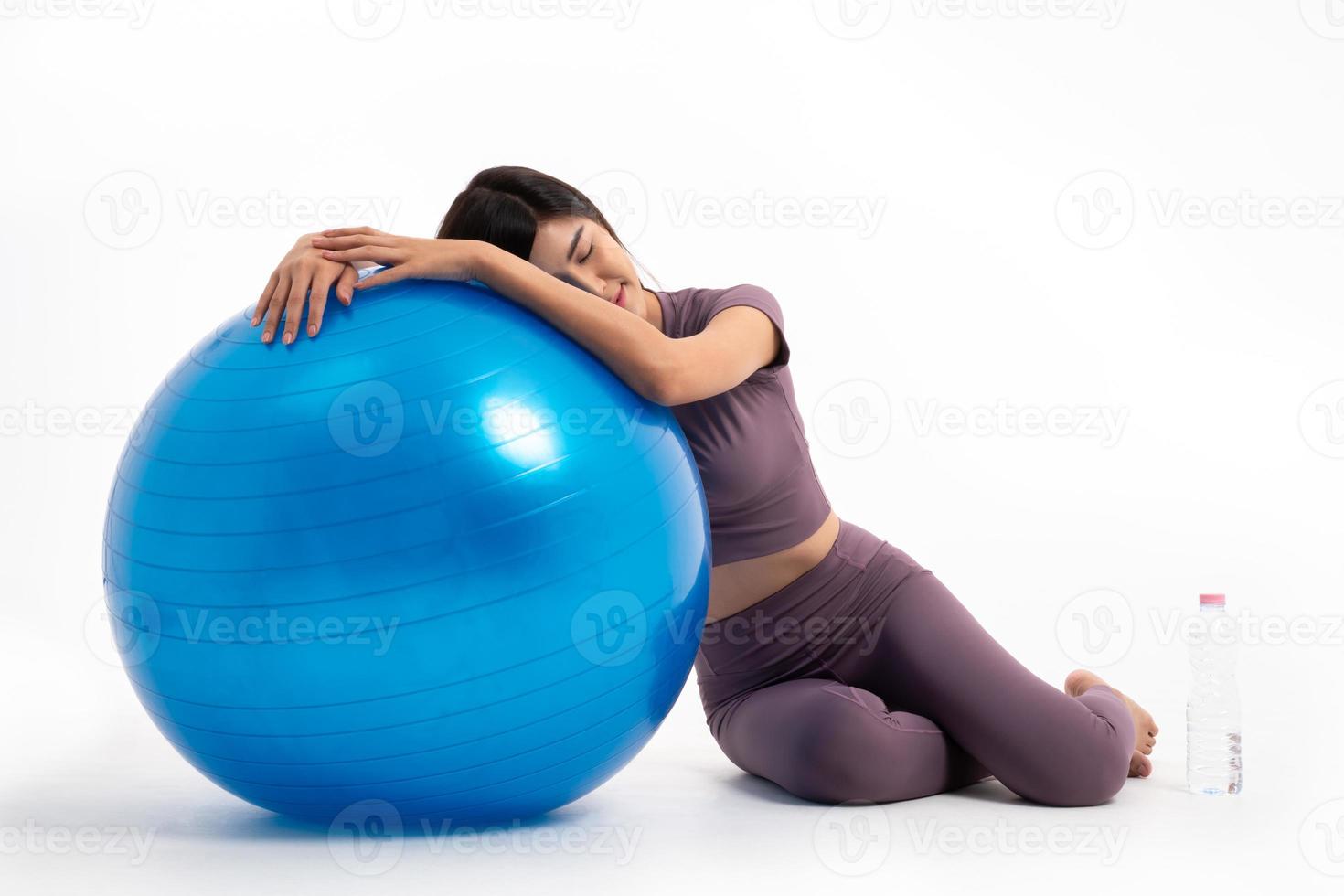 Healthy Asian woman Rest over by lying on the ball after a workout with fitball on isolated white background, Concept of good health starts with exercise. photo