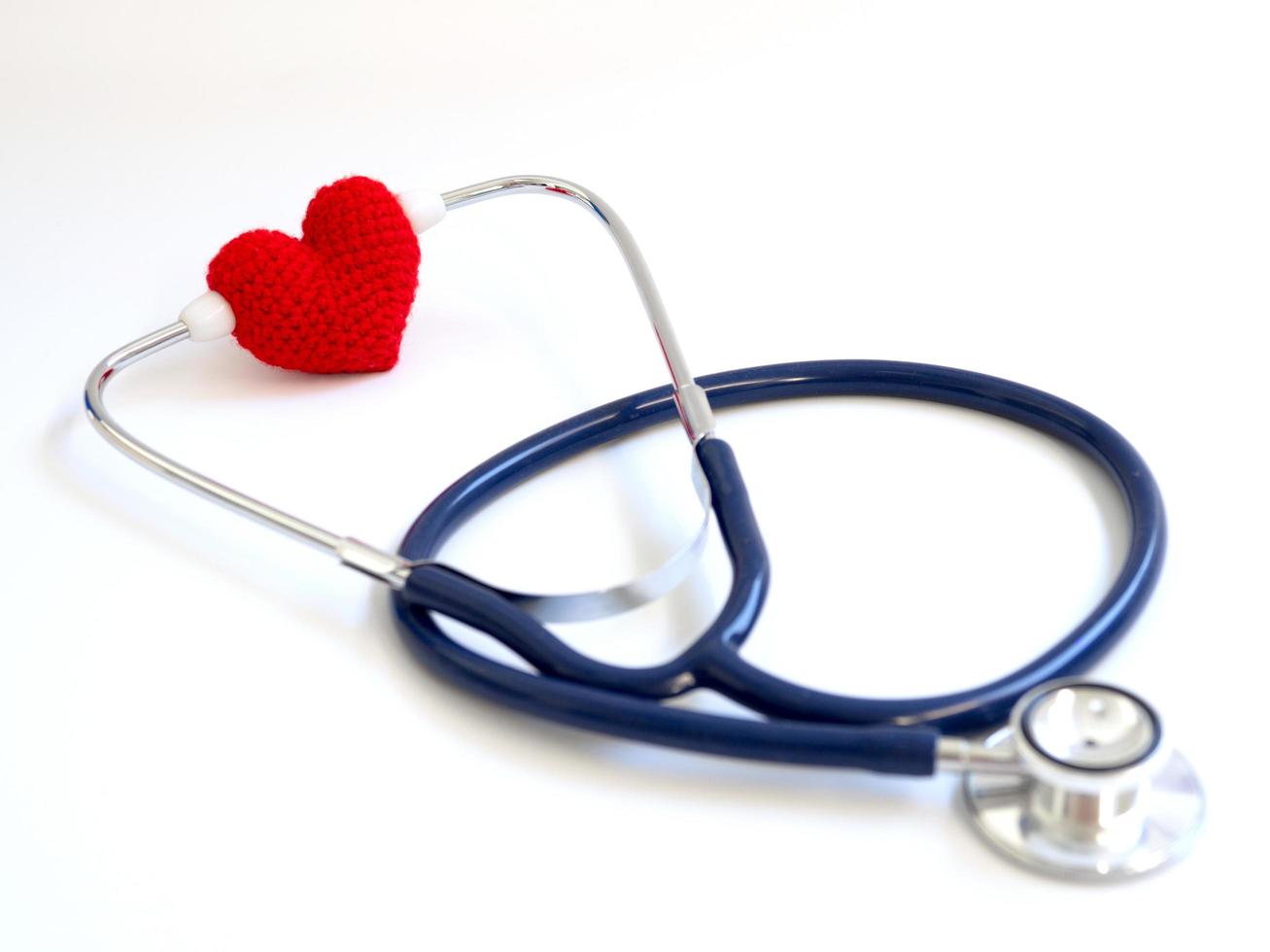 red heart using stethoscope on the white background Isolated background.  Concept of love and caring patient by the heart. Copy space for the text and contents photo