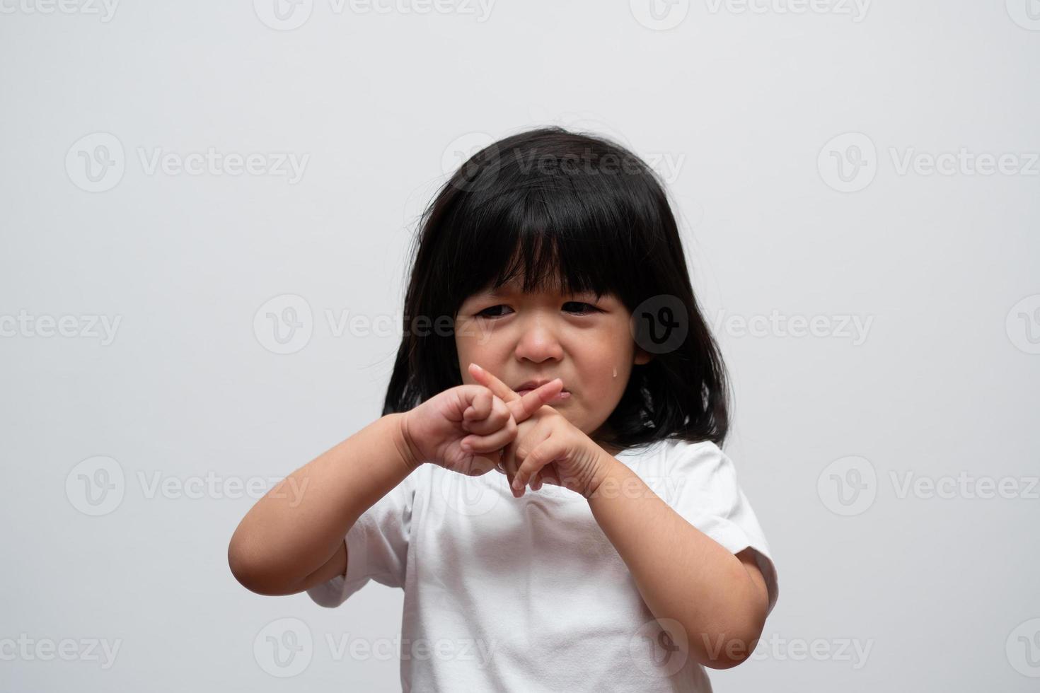 Portrait of Asian angry, sad and cry little girl on white isolated background, The emotion of a child when tantrum and mad, expression grumpy emotion. Kid emotional control concept photo