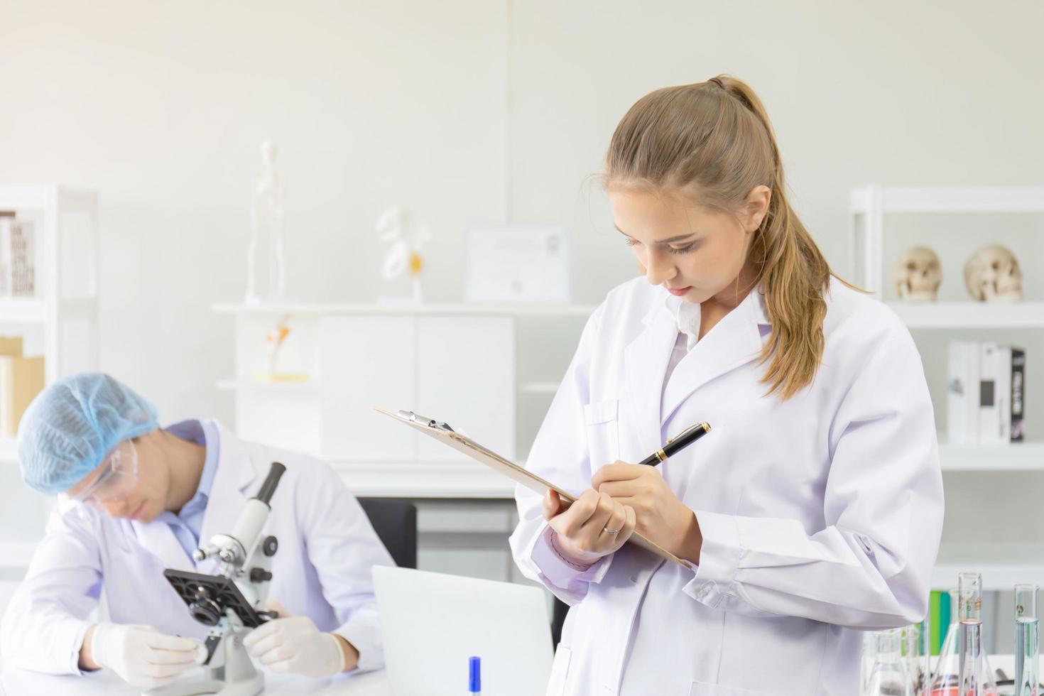 Scientists, young men and women in the laboratory and have a beautiful orange light. photo