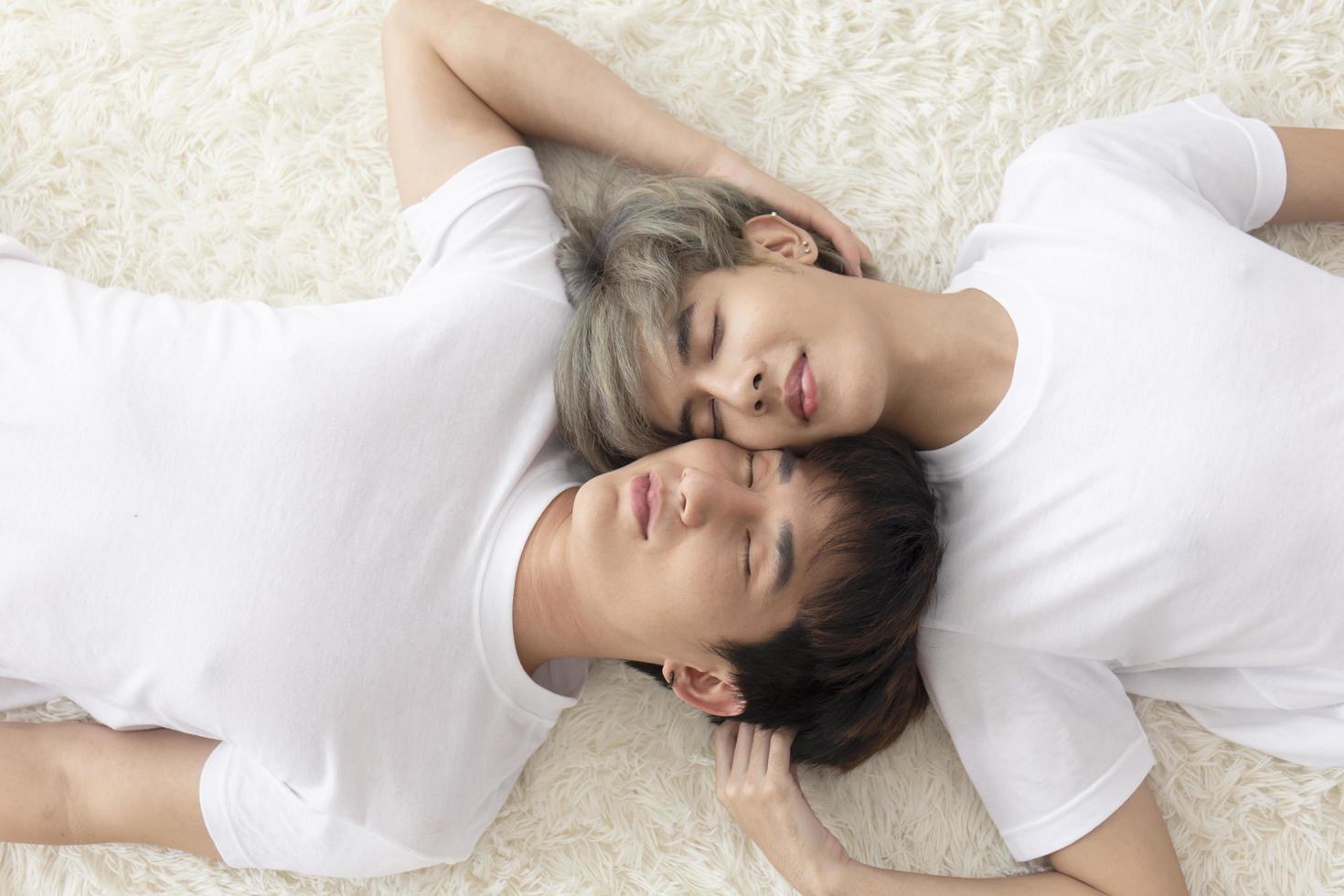A male couple with an Asian man sleep together in a bed, a symbol of sexual diversity, expressing openly gay men accepting LGBT concepts. photo