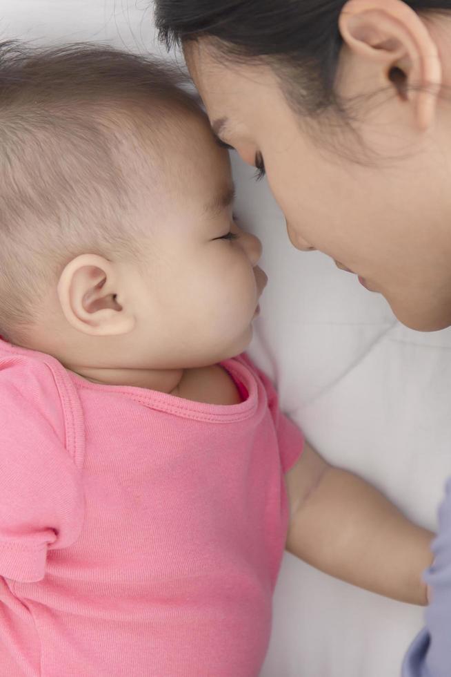 Mother and baby sleep together in bed. photo