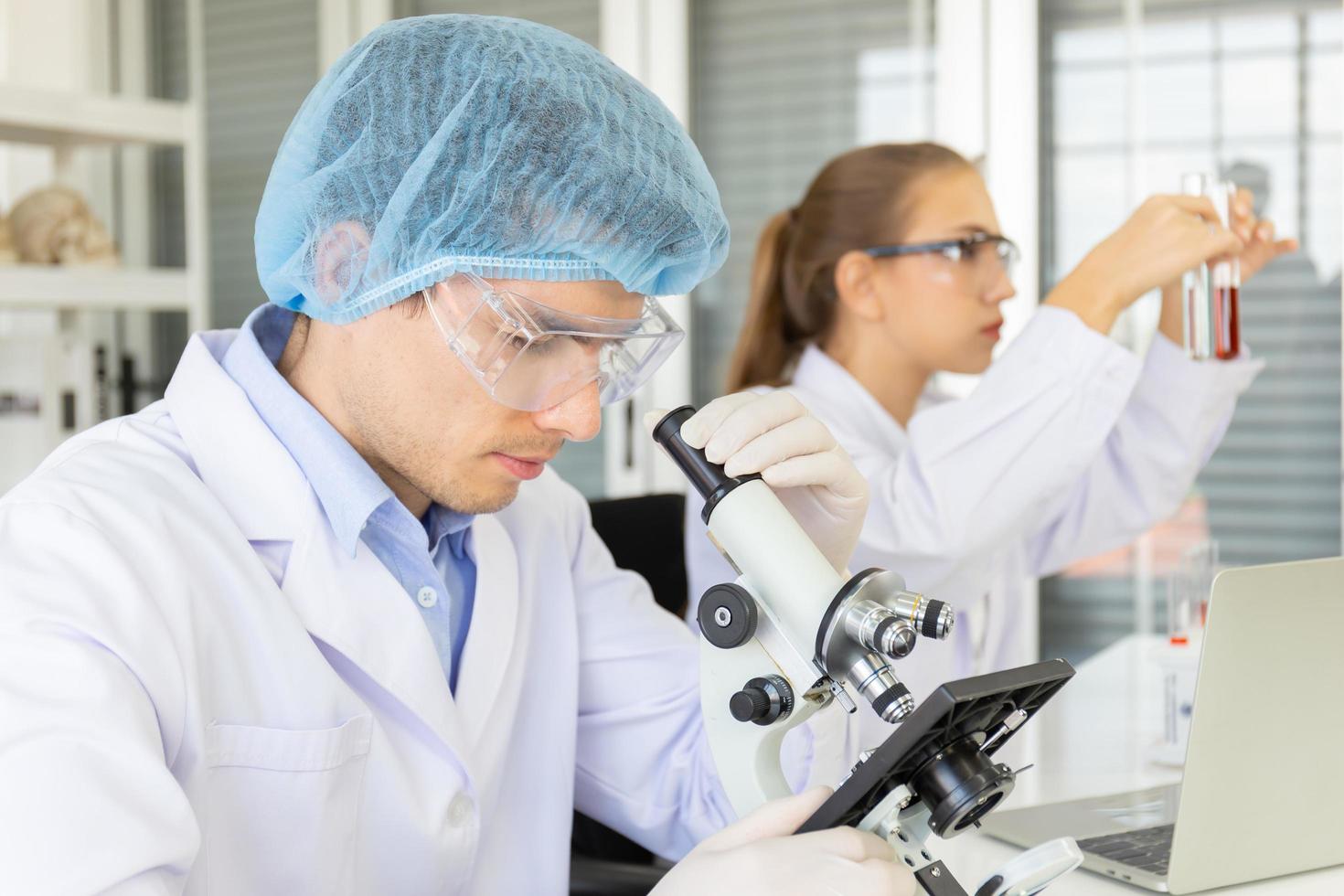 Two Scientists Chemistry Technology, Biology  A new generation of scientists shaking a glass containing reagents and conducting tests or research in laboratories. photo