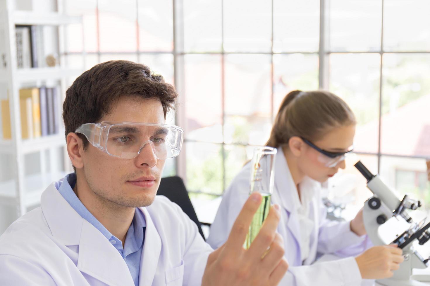 Male and female scientists working in a science laboratory with various