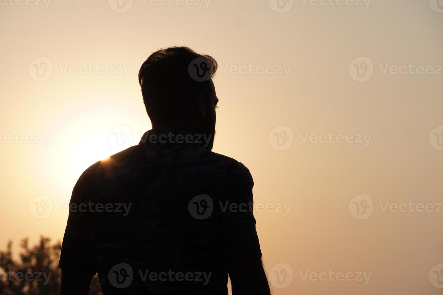 silueta de hombre viendo la puesta de sol sobre el mar. silueta masculina y puesta de sol en el mar. foto