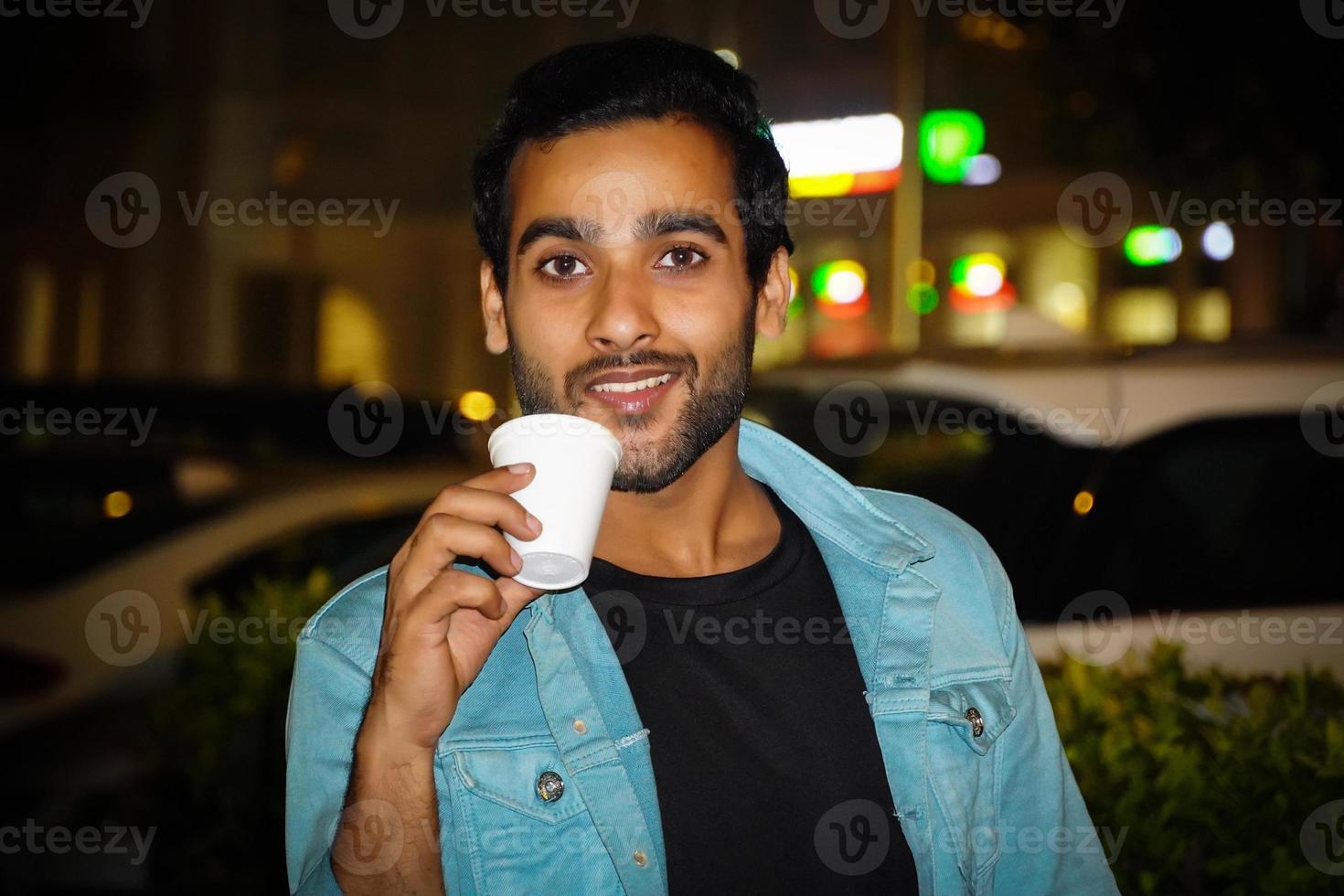 un joven tomando una taza de té disfrutando de su té foto