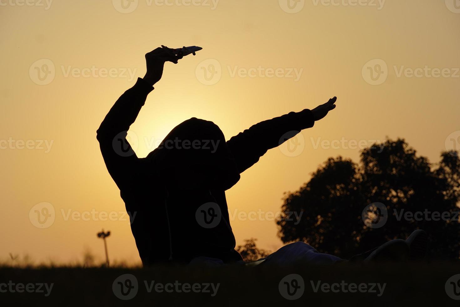 Happy young boy with a toy airplane on a sunset background over a wheat field photo