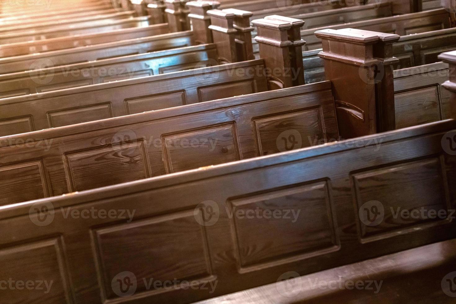 Cathedral pews. Rows of benches in christian church. Heavy solid uncomfortable wooden seats. photo