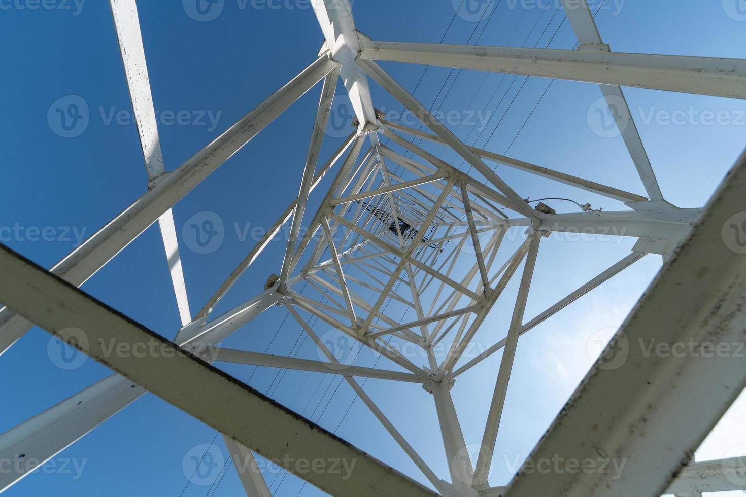 Transmission tower, view from below. Overhead pylon power line tower, distribution and transmit electrical energy across large distances. photo