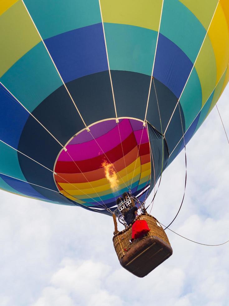 globo aerostático brillante y colorido despega mostrando el quemador de la canasta y la llama foto