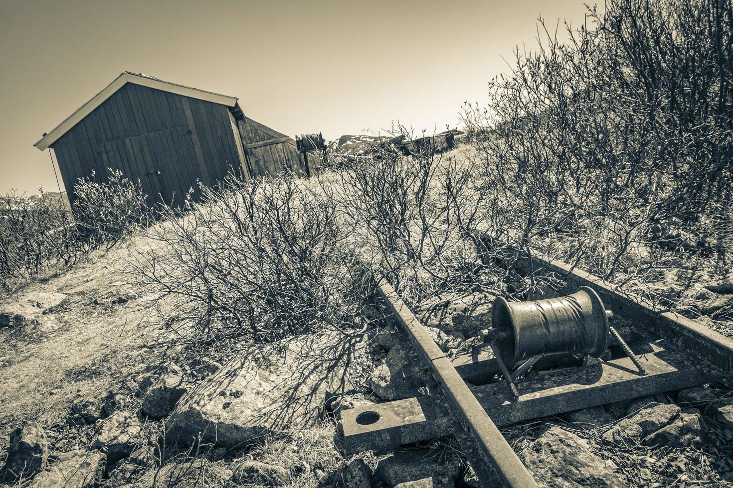 Old rails lead into water of frozen lake Vavatn Hemsedal. photo