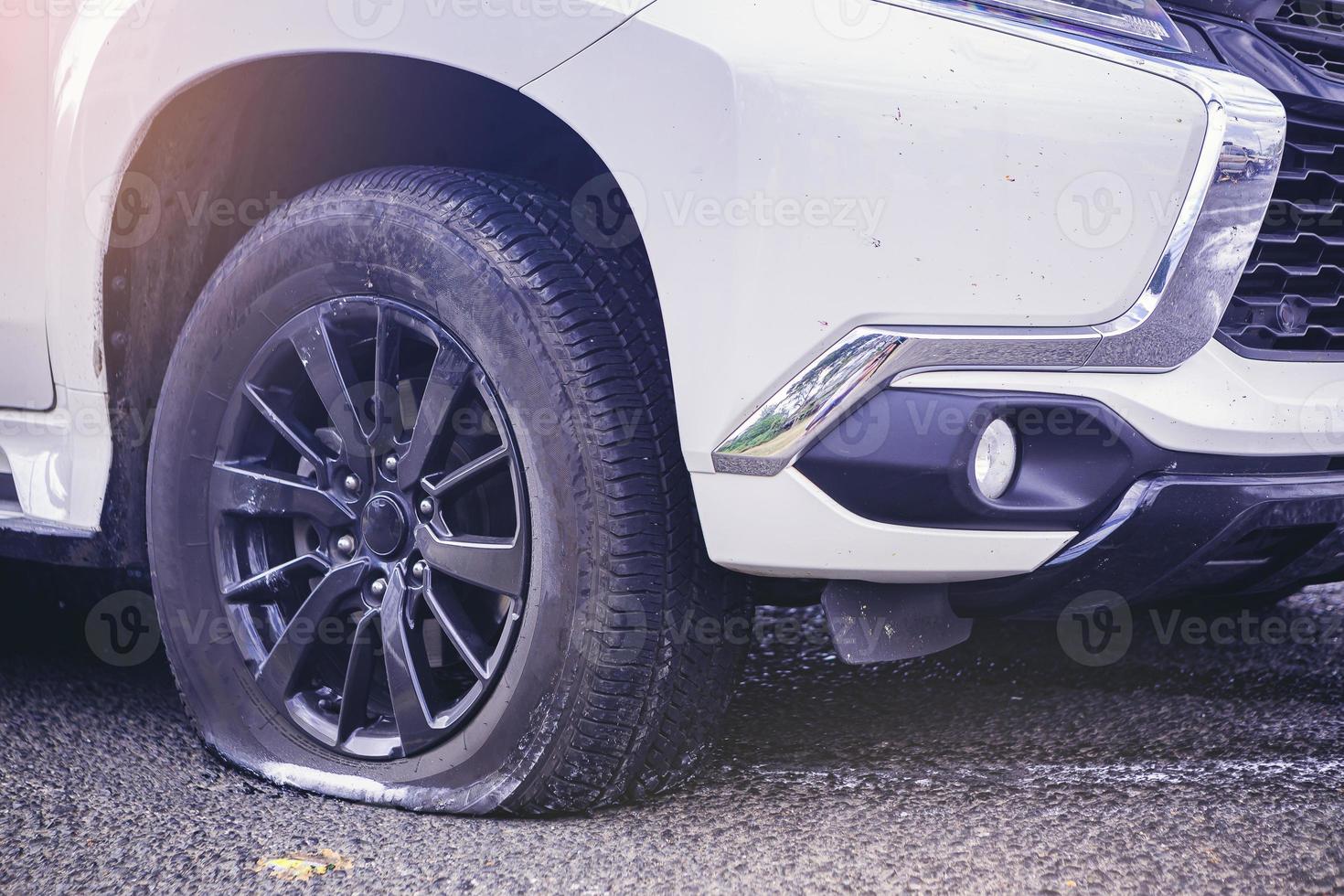 Close up of a car flat tire, air tire pressure lose on the road. photo