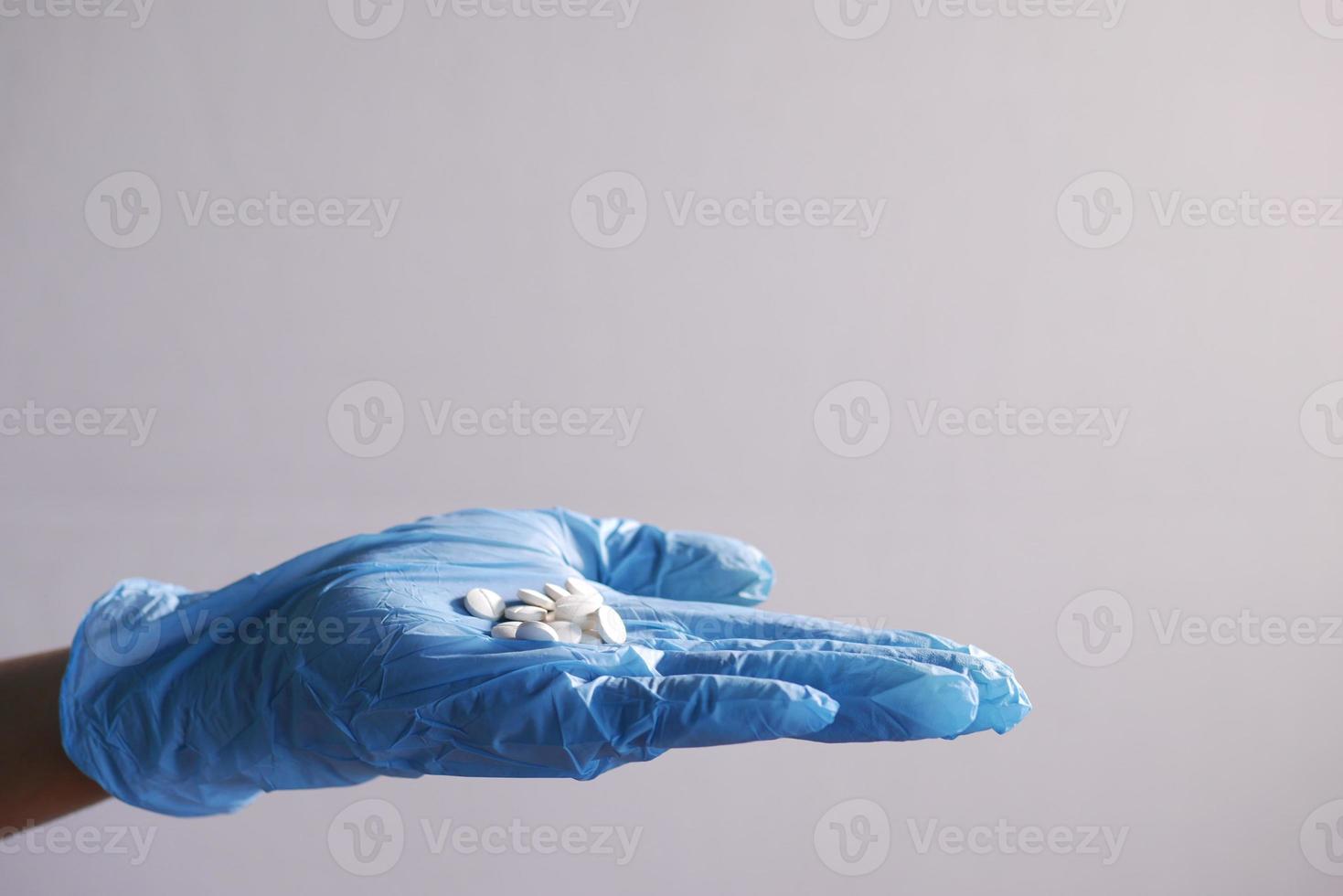 hand in a latex gloves white medical pills on hand photo