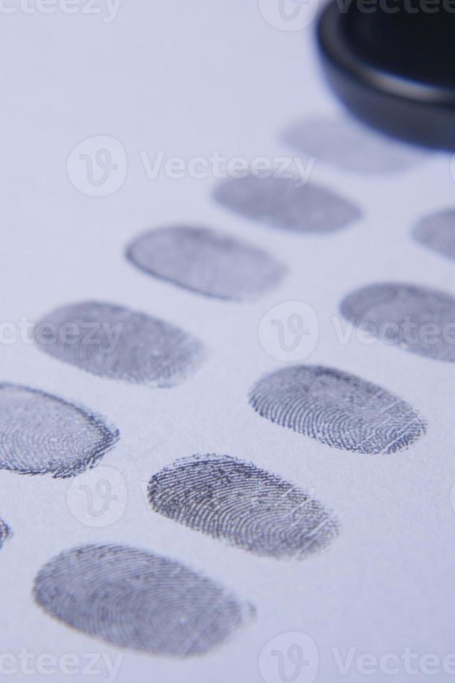 different black fingerprints on a paper close up , photo