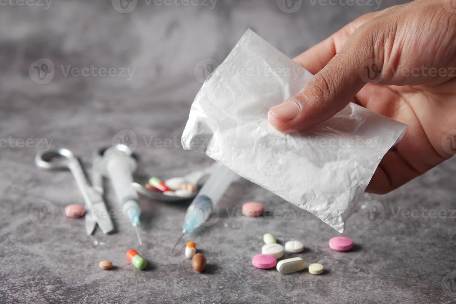 drug addiction concept with hand holding heroine packet on black backgrund photo