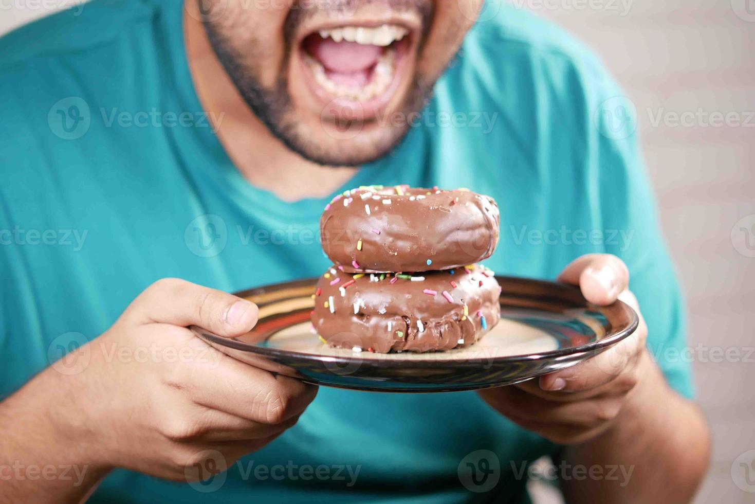 young man eating donut , selective focus photo