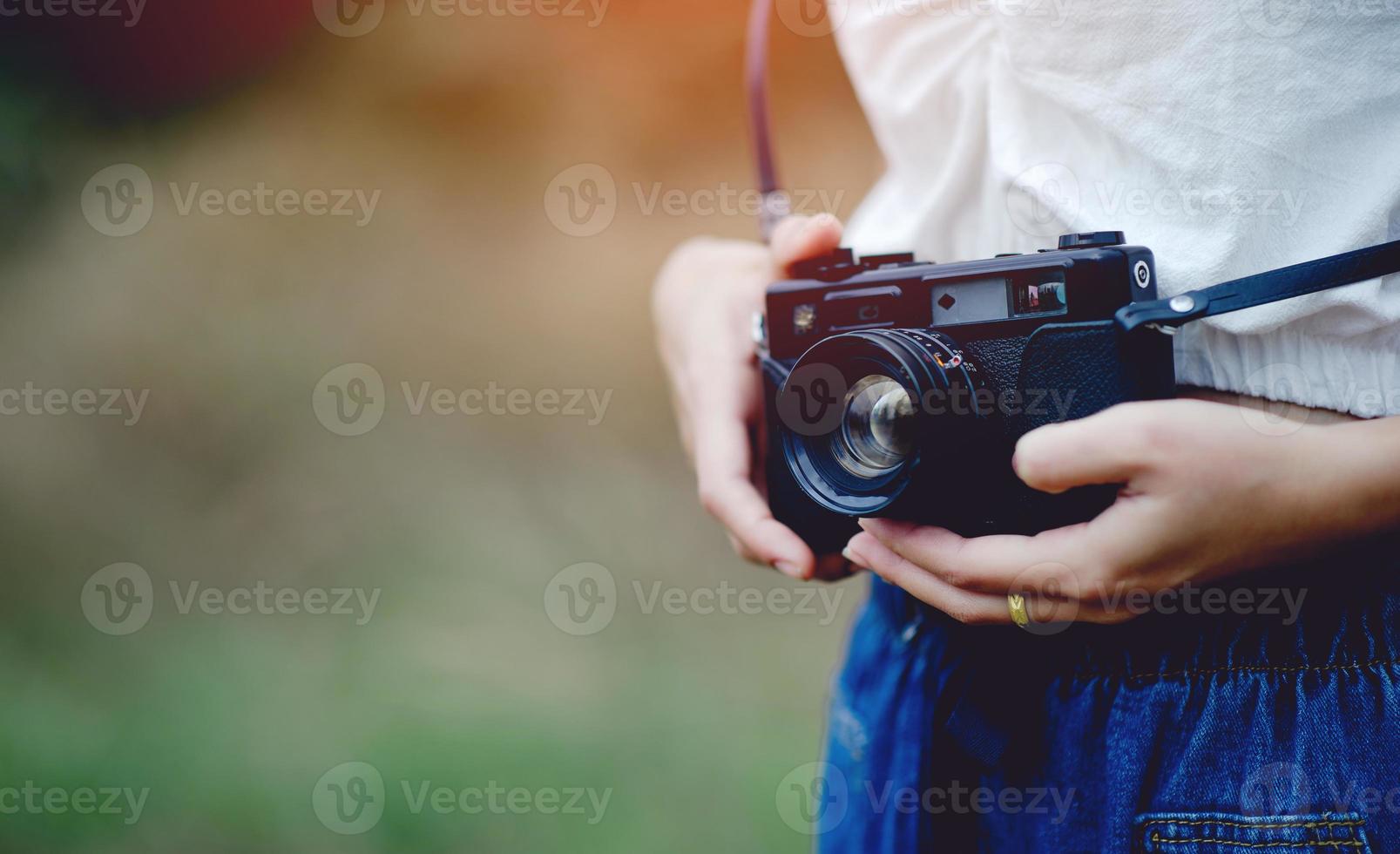 mano y cámara del fotógrafo sosteniendo y llevando la cámara para tomar fotografías foto